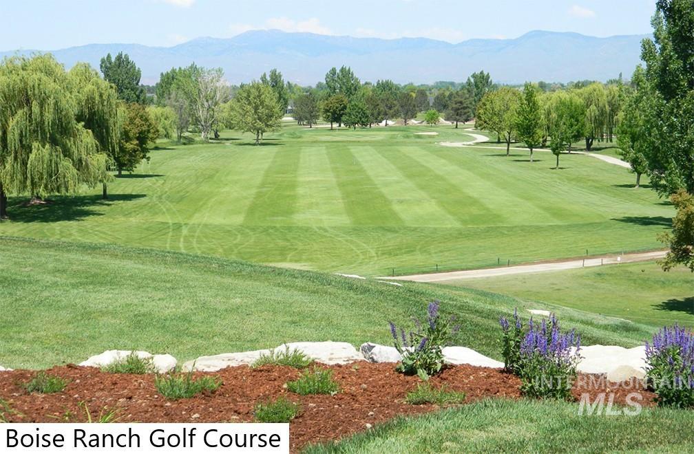 View of home's community featuring a mountain view, golf course view, view of wooded area, and a lawn