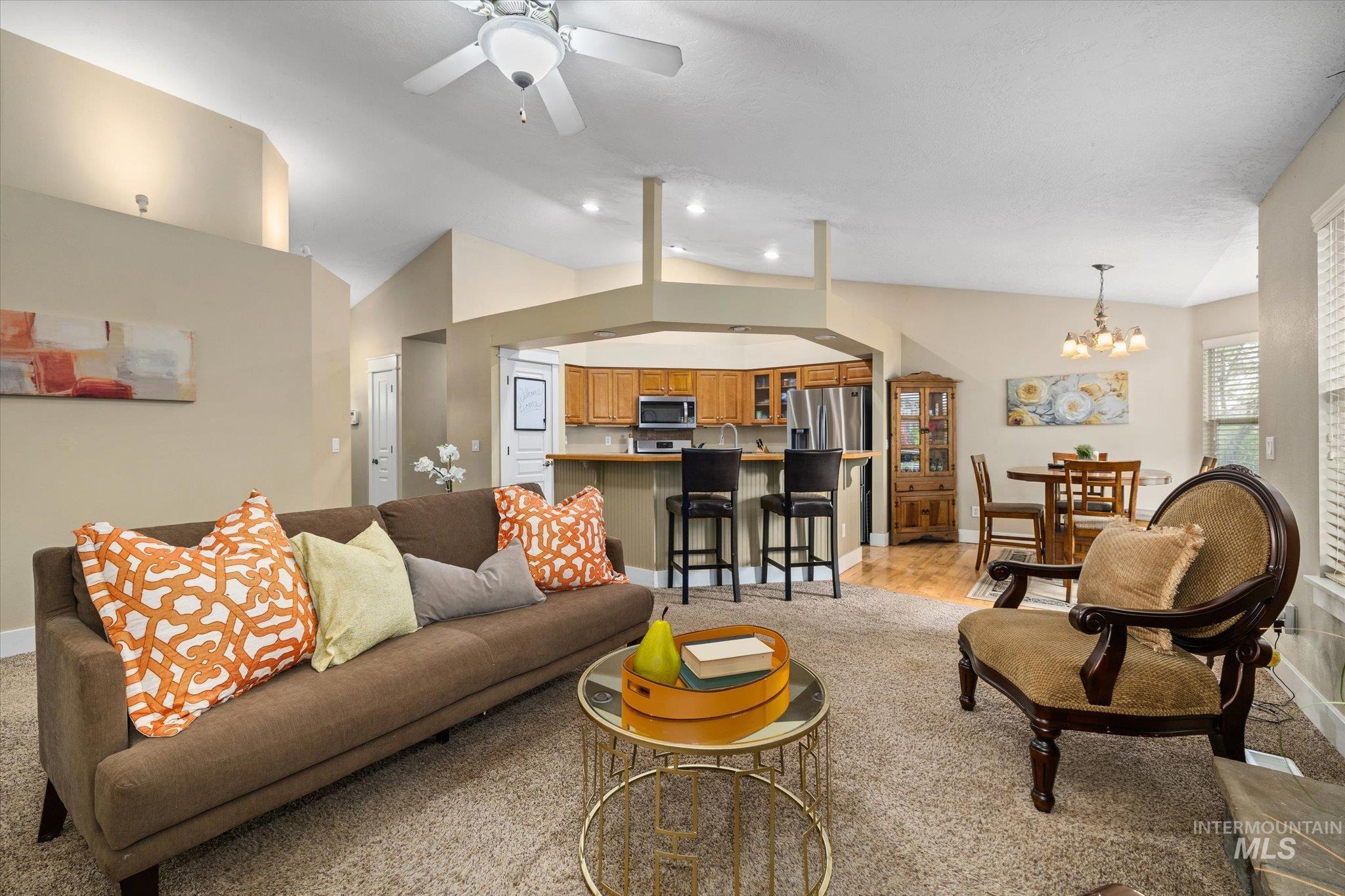 Living area featuring vaulted ceiling, a chandelier, ceiling fan, and recessed lighting