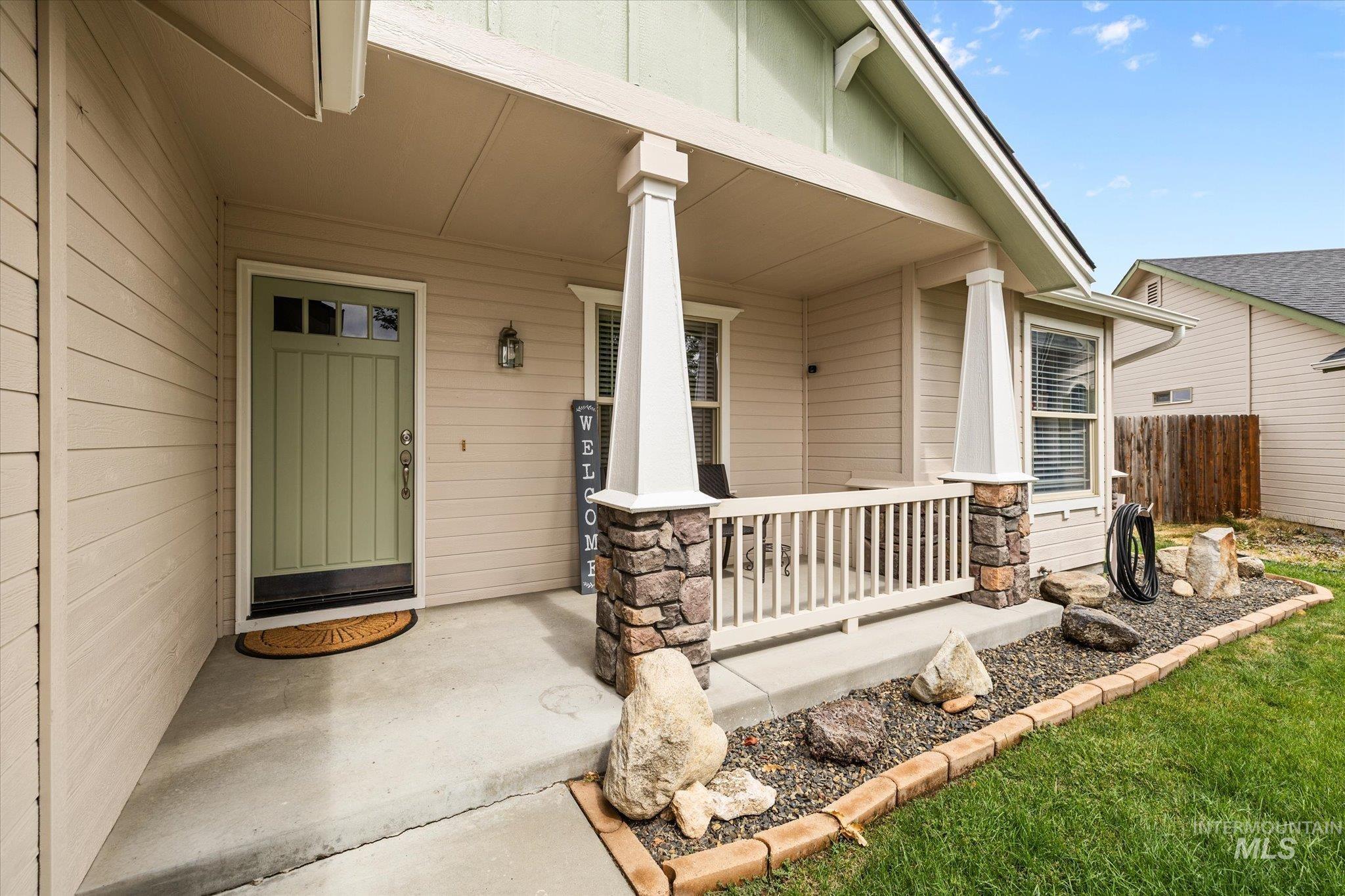 Doorway to property with covered porch and stone siding