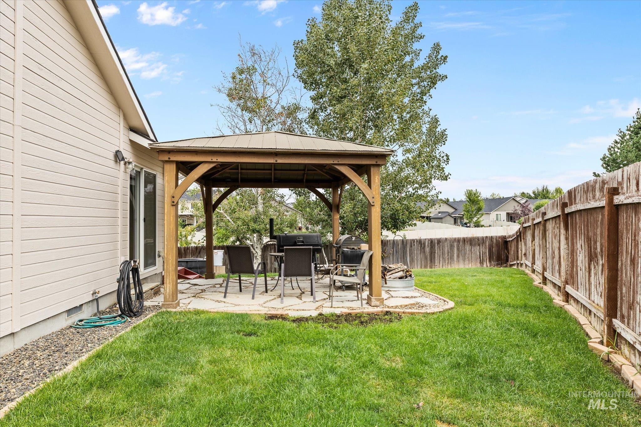 Fenced backyard featuring a gazebo and a patio area