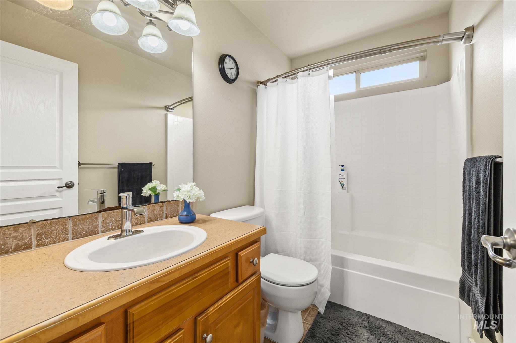 Full bathroom with shower / bath combination with curtain and vanity