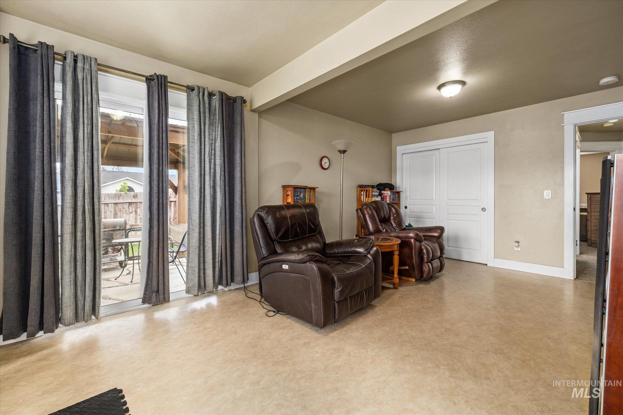 Sitting room with beamed ceiling and light flooring