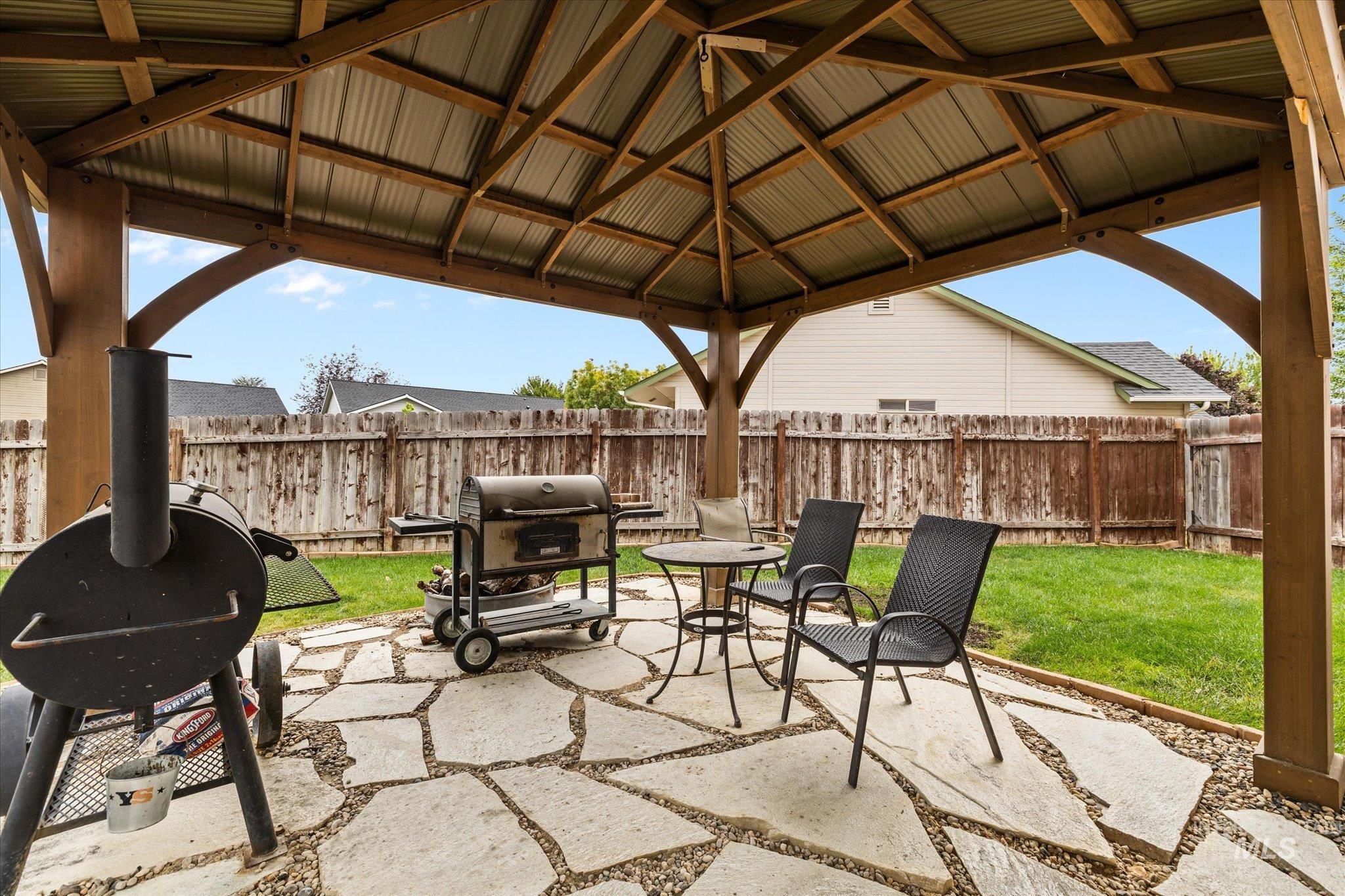 Fenced backyard with a patio area and grilling area