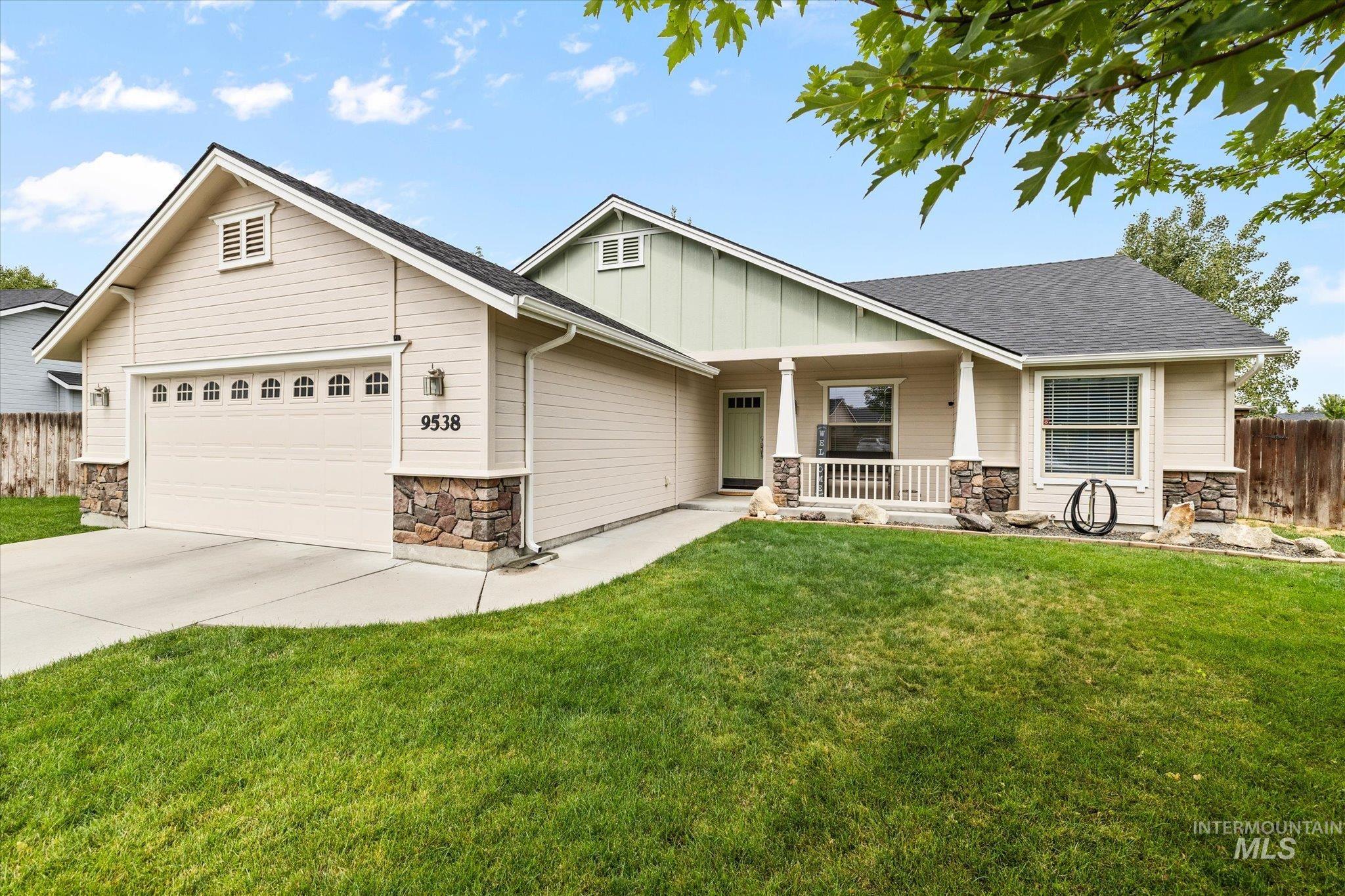 Craftsman-style home with stone siding, a porch, roof with shingles, and driveway