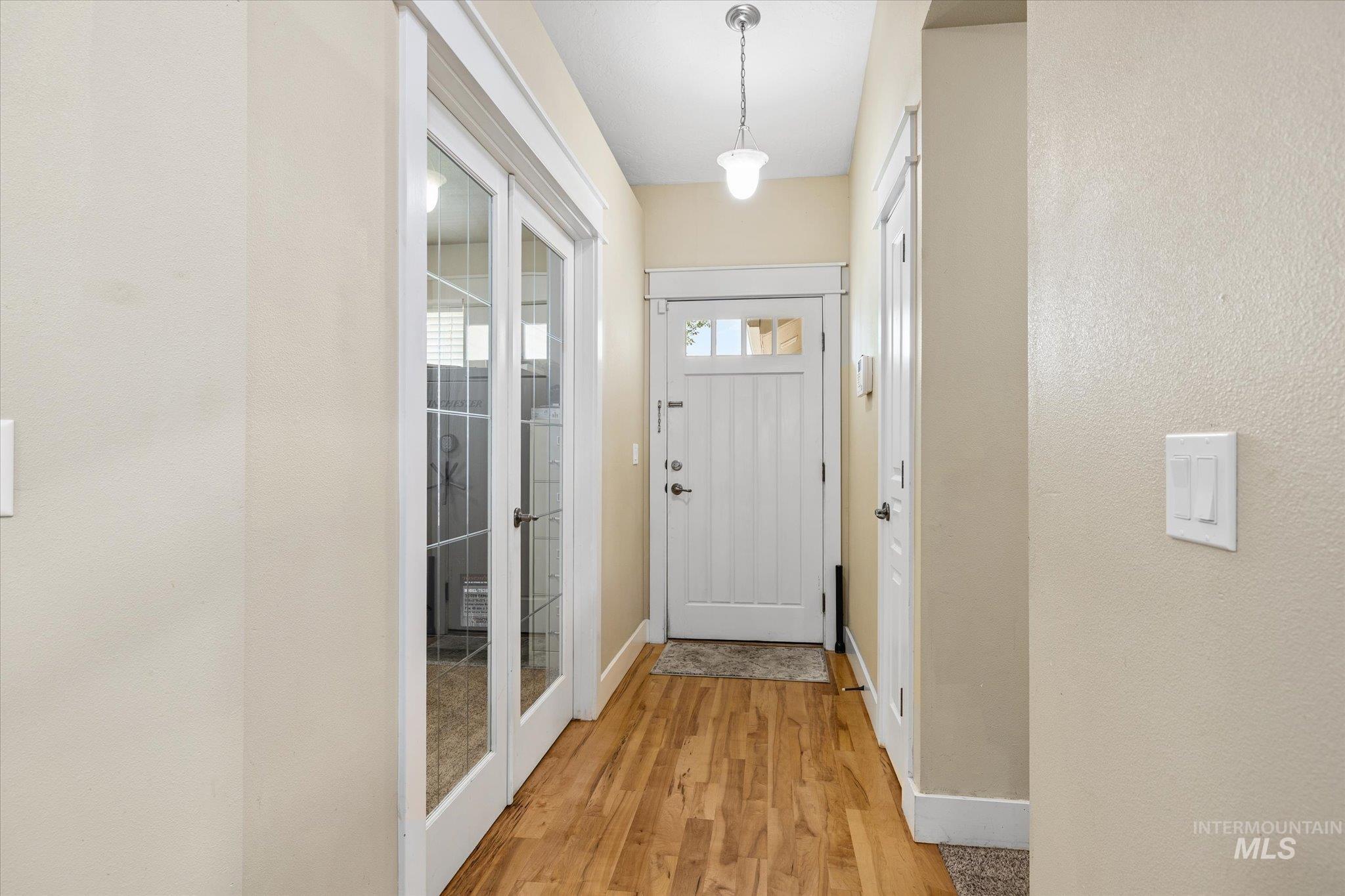 Doorway featuring wood finished floors and baseboards