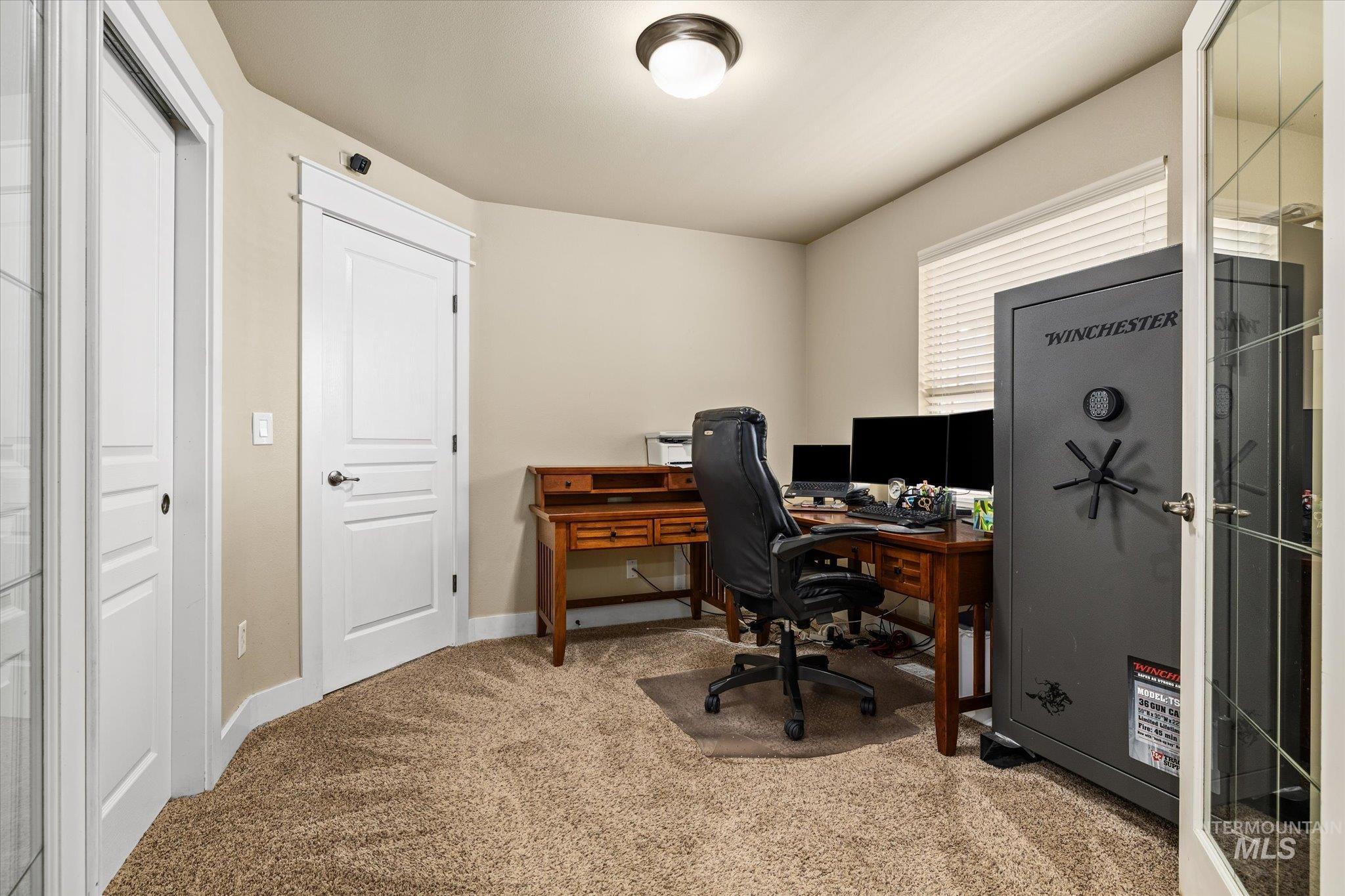 Home office with light colored carpet and baseboards