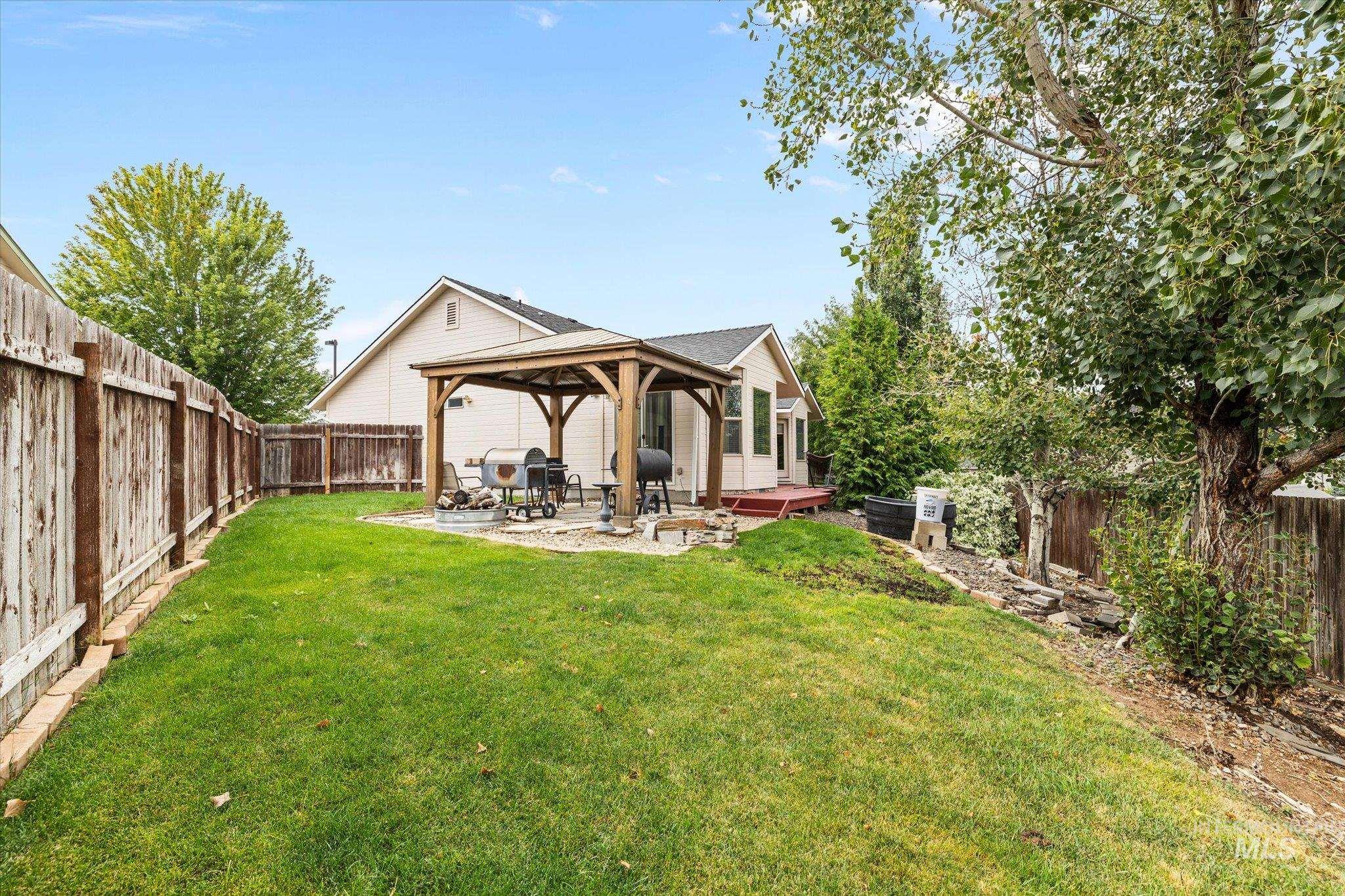 Rear view of house featuring a gazebo, a patio, and a fenced backyard