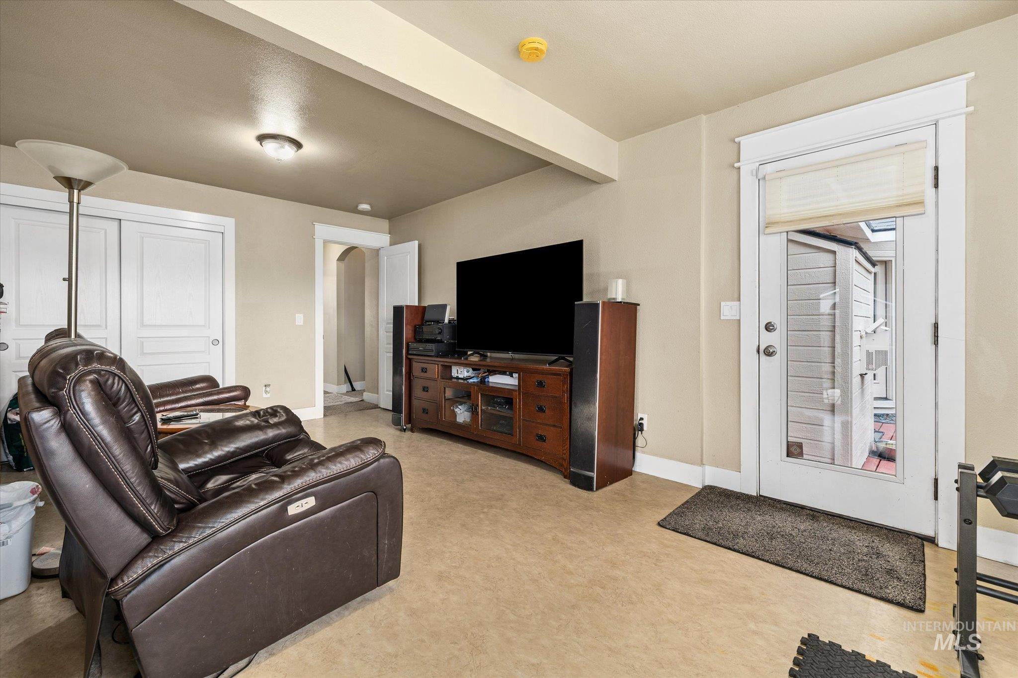 Living room featuring beam ceiling and arched walkways