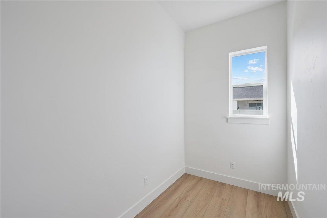 Empty room with baseboards and light wood-style flooring