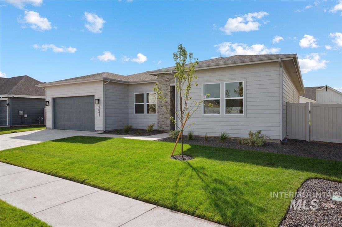 Single story home with a front yard, a garage, driveway, and a gate