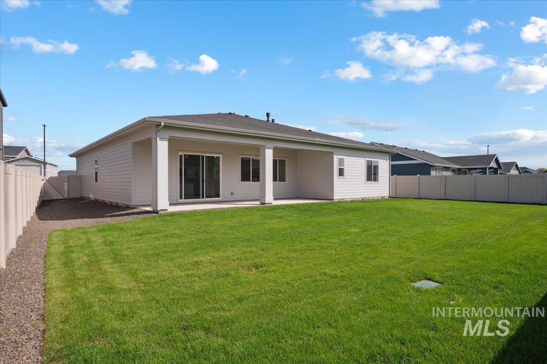 Back of house with a fenced backyard and a patio area