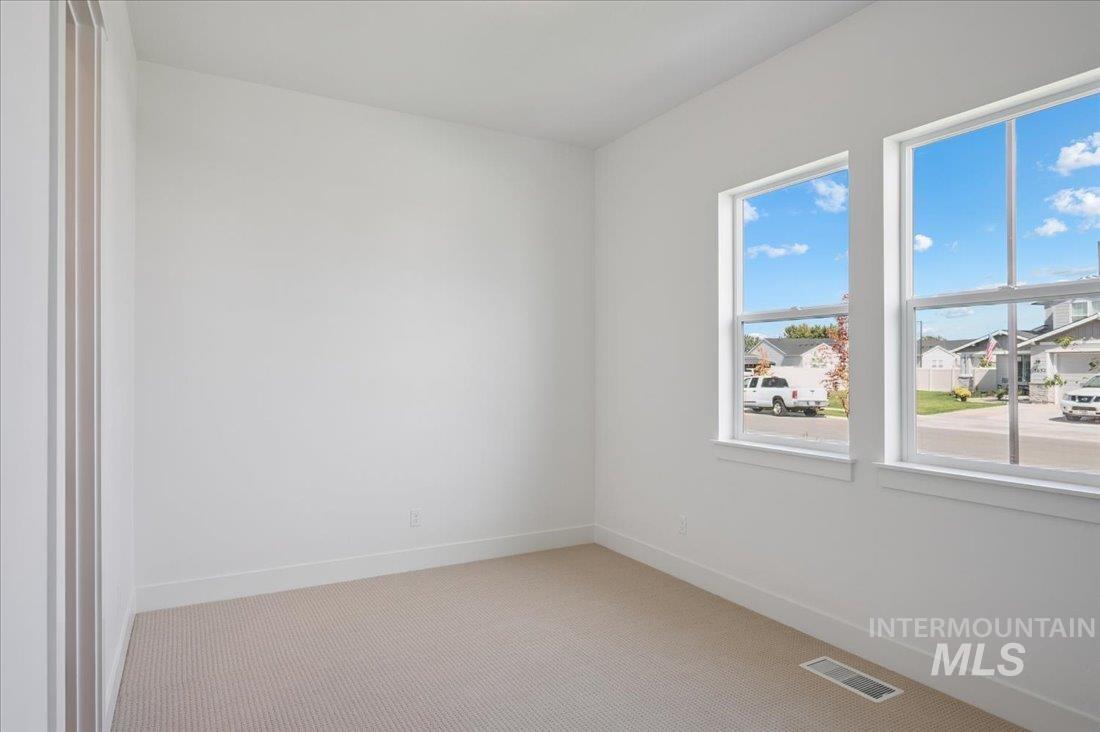 Unfurnished room featuring carpet flooring and a residential view
