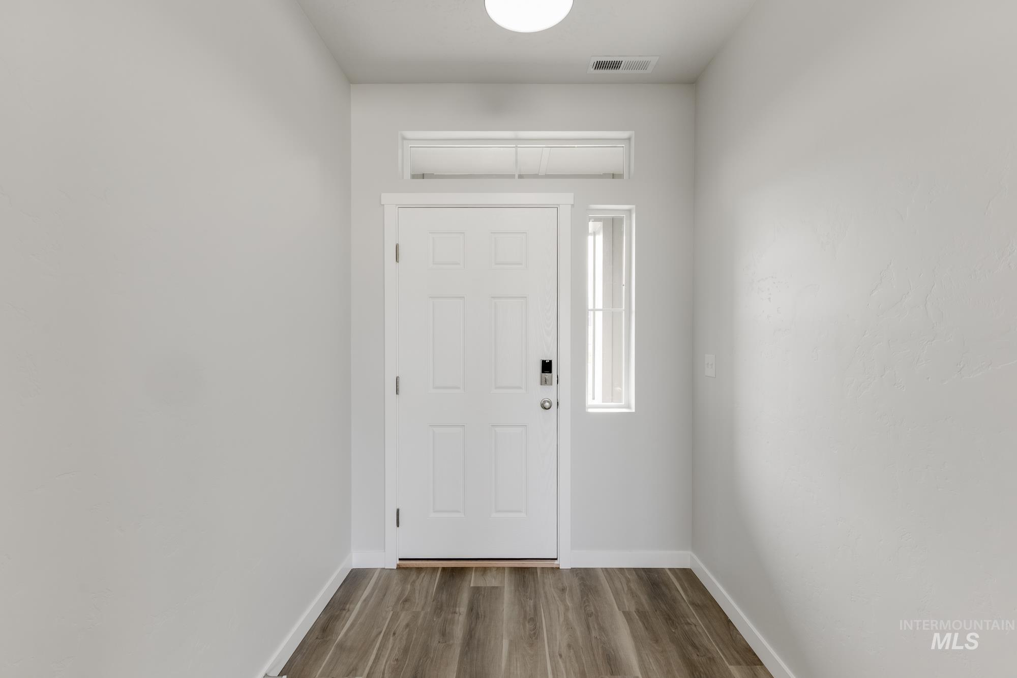 Entryway with wood finished floors and baseboards