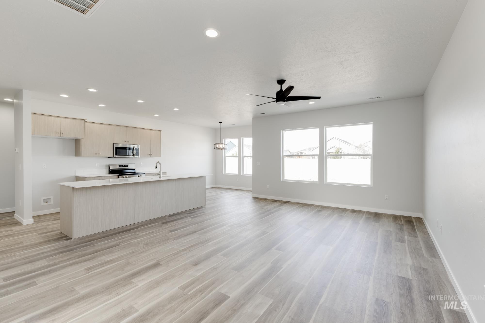 Kitchen featuring a center island with sink, open floor plan, recessed lighting, appliances with stainless steel finishes, and light wood finished floors