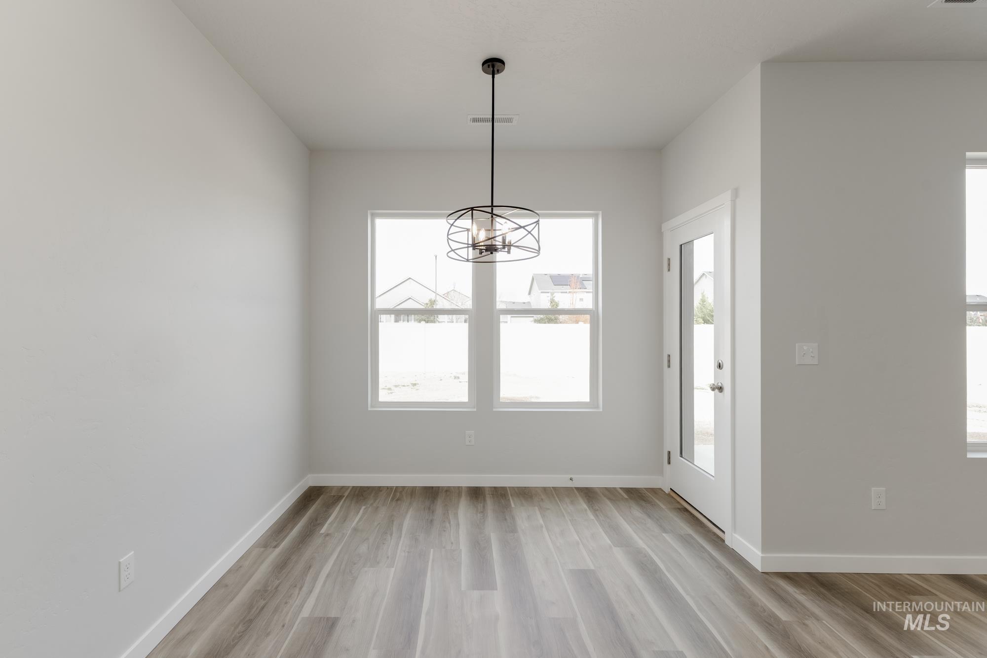 Unfurnished dining area with light wood-style flooring and a chandelier