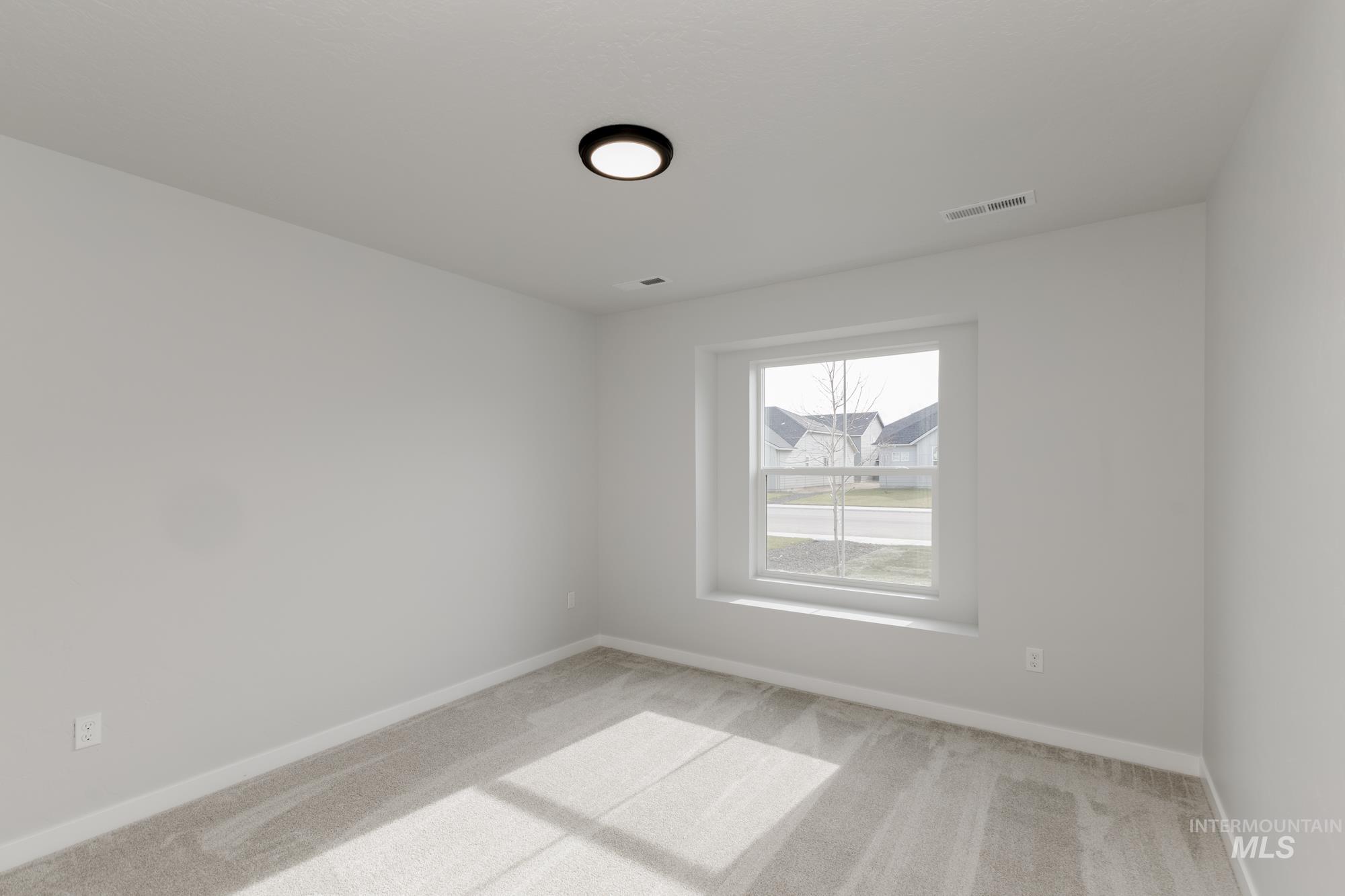 Empty room featuring light carpet and baseboards
