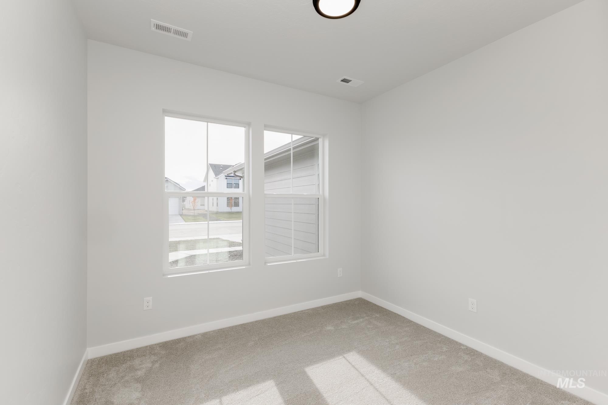 Carpeted spare room with baseboards