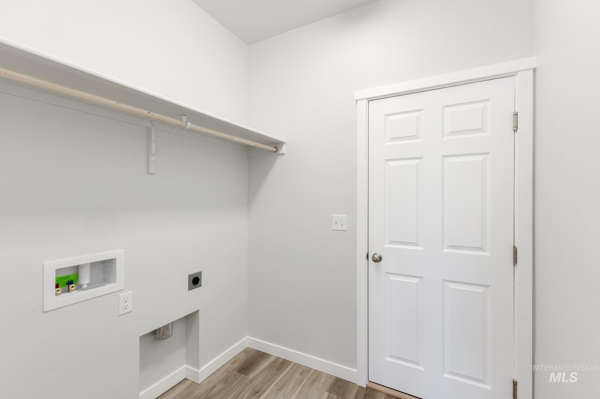 Laundry area featuring light wood finished floors, electric dryer hookup, and washer hookup