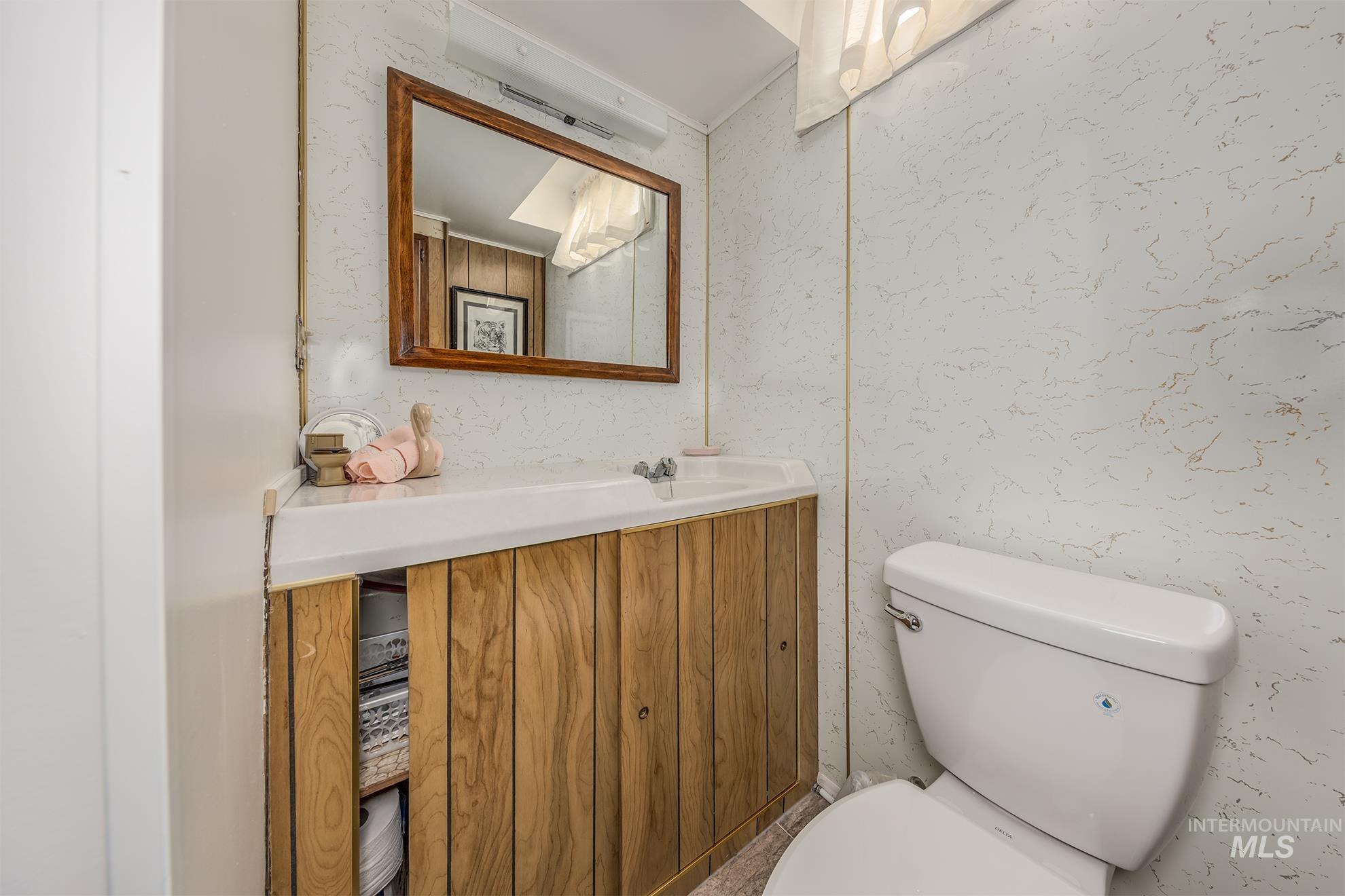 Half bathroom featuring vanity and toilet