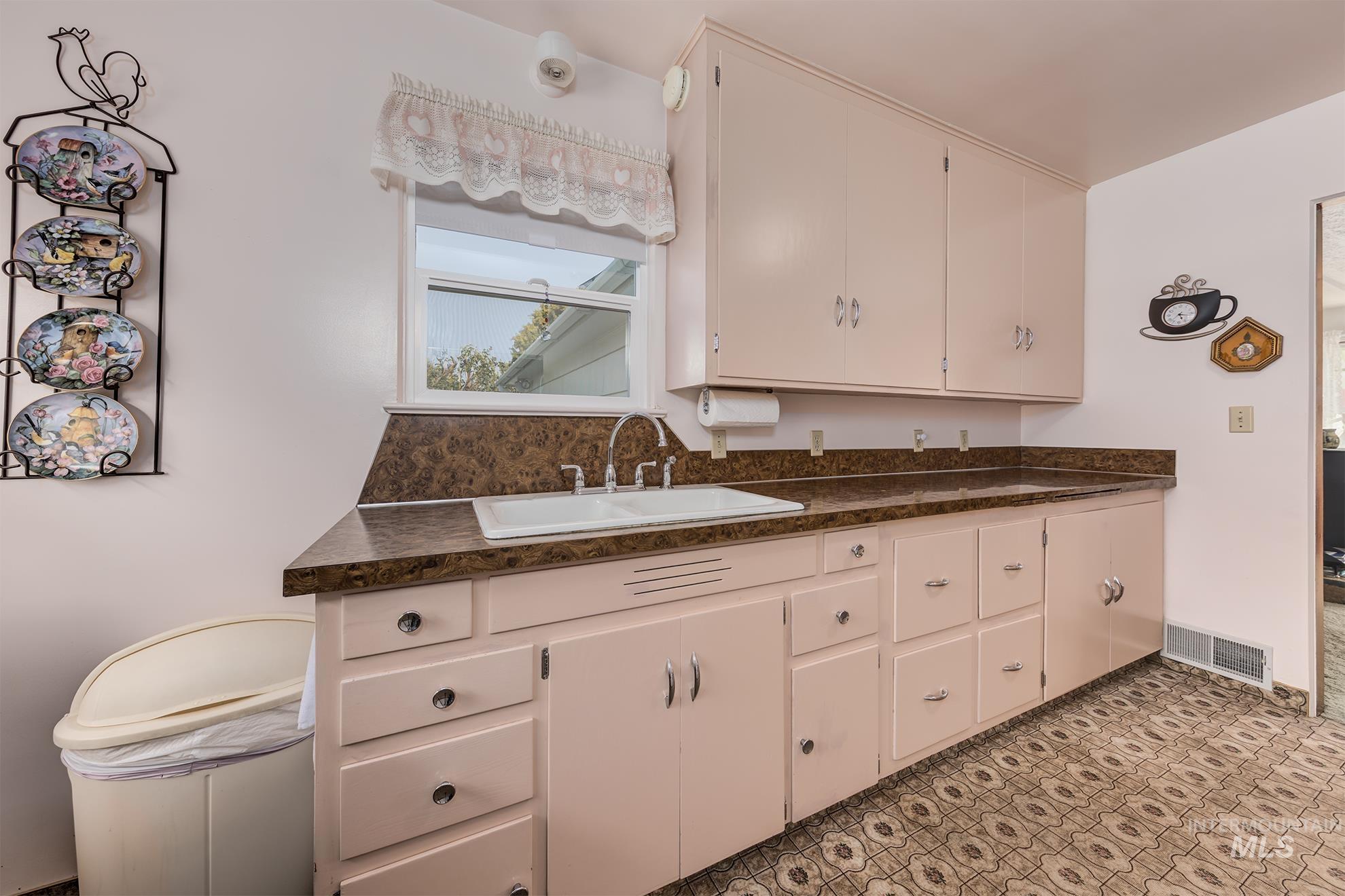 Kitchen with dark countertops and white cabinetry