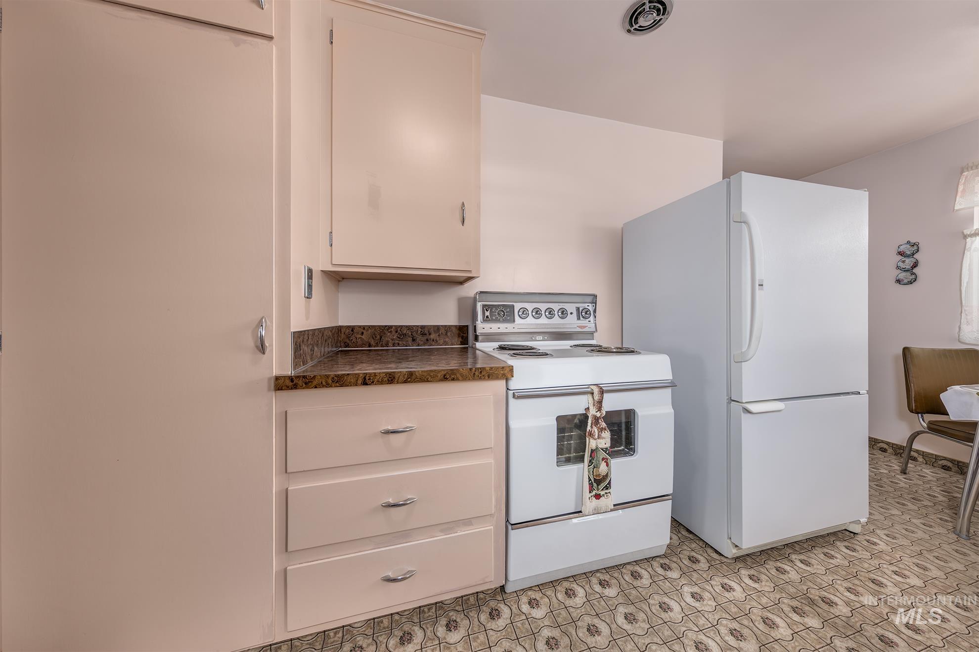 Kitchen featuring white appliances and dark countertops