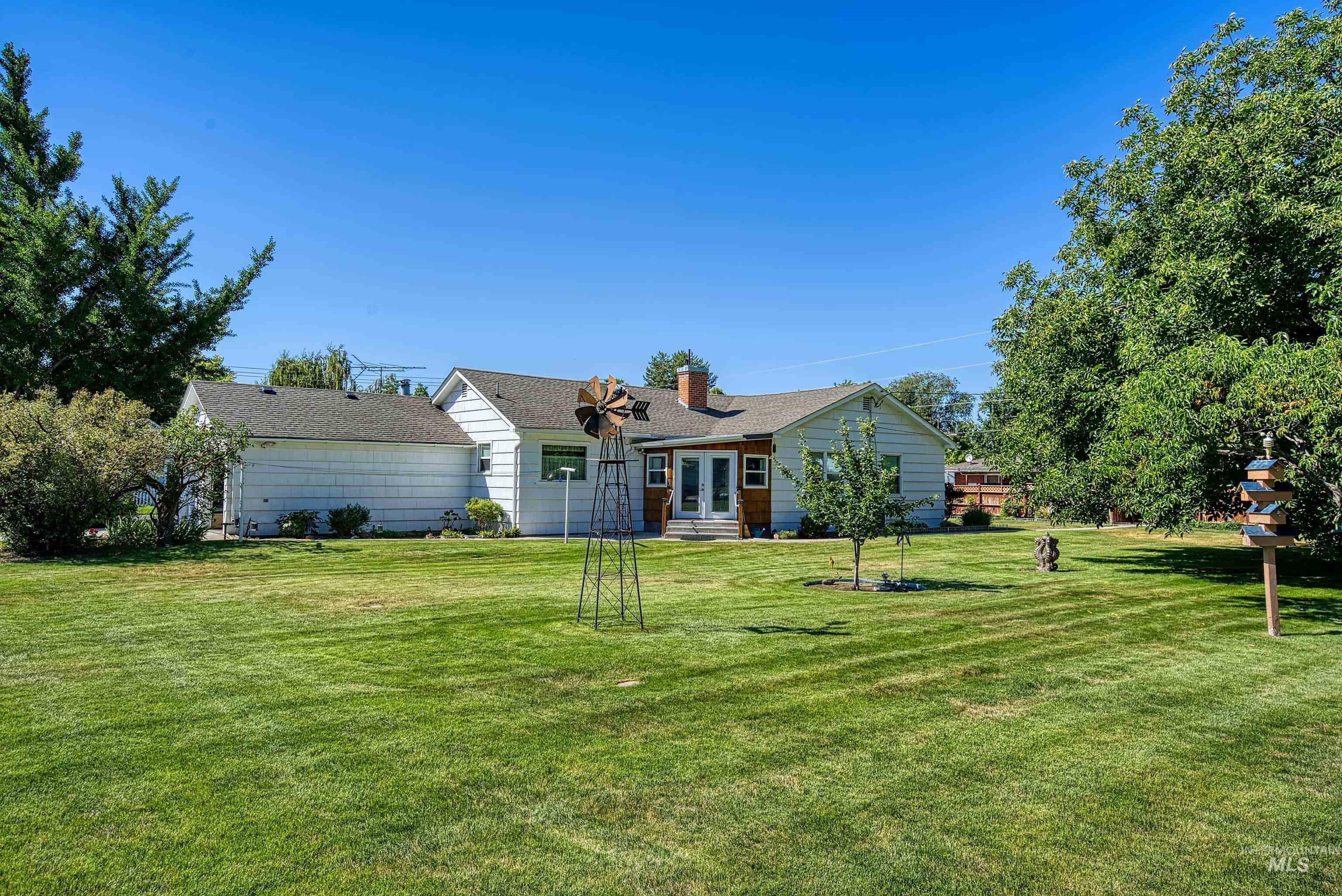 Ranch-style house with a front yard, a chimney, and roof with shingles
