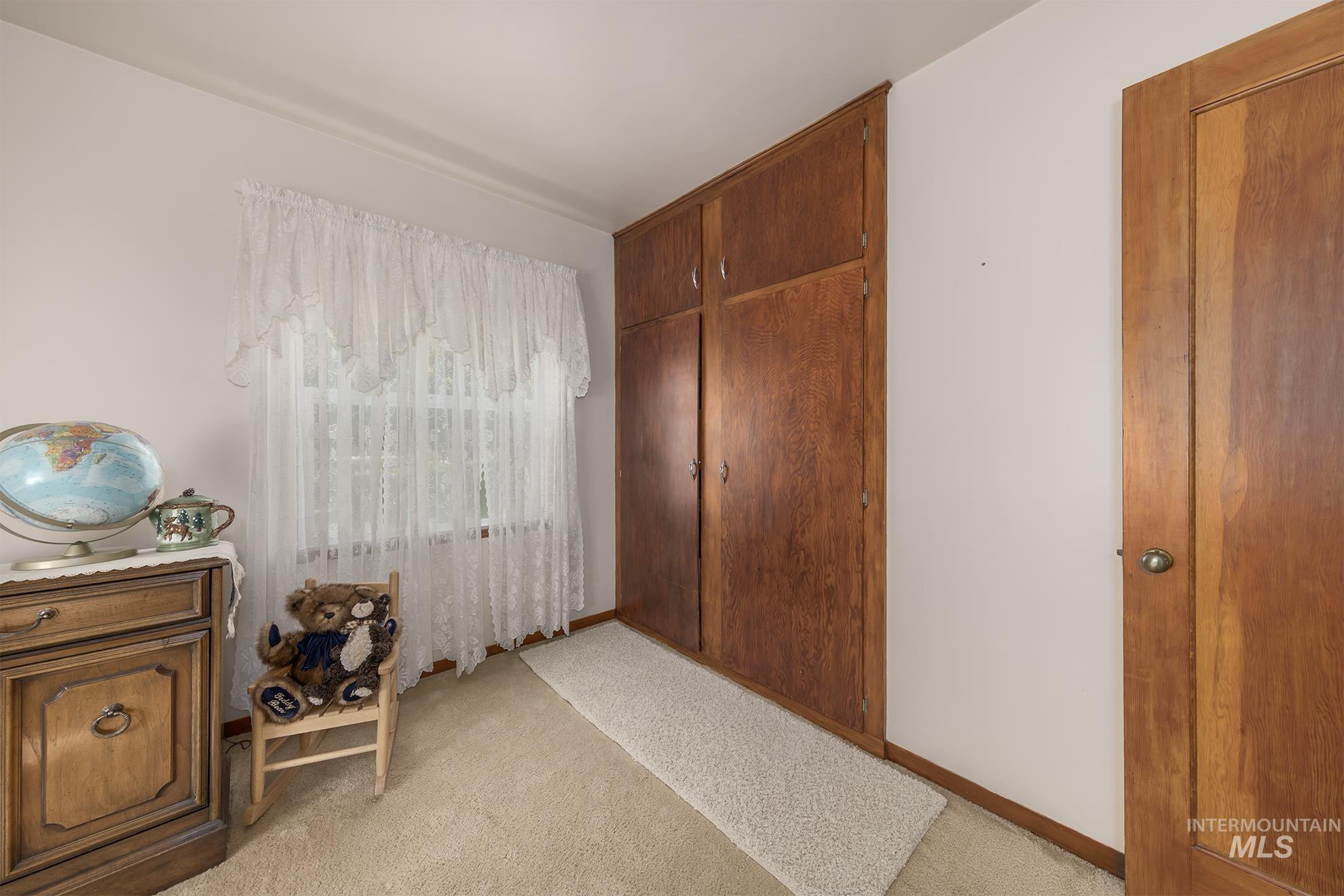 Bedroom featuring light colored carpet and baseboards