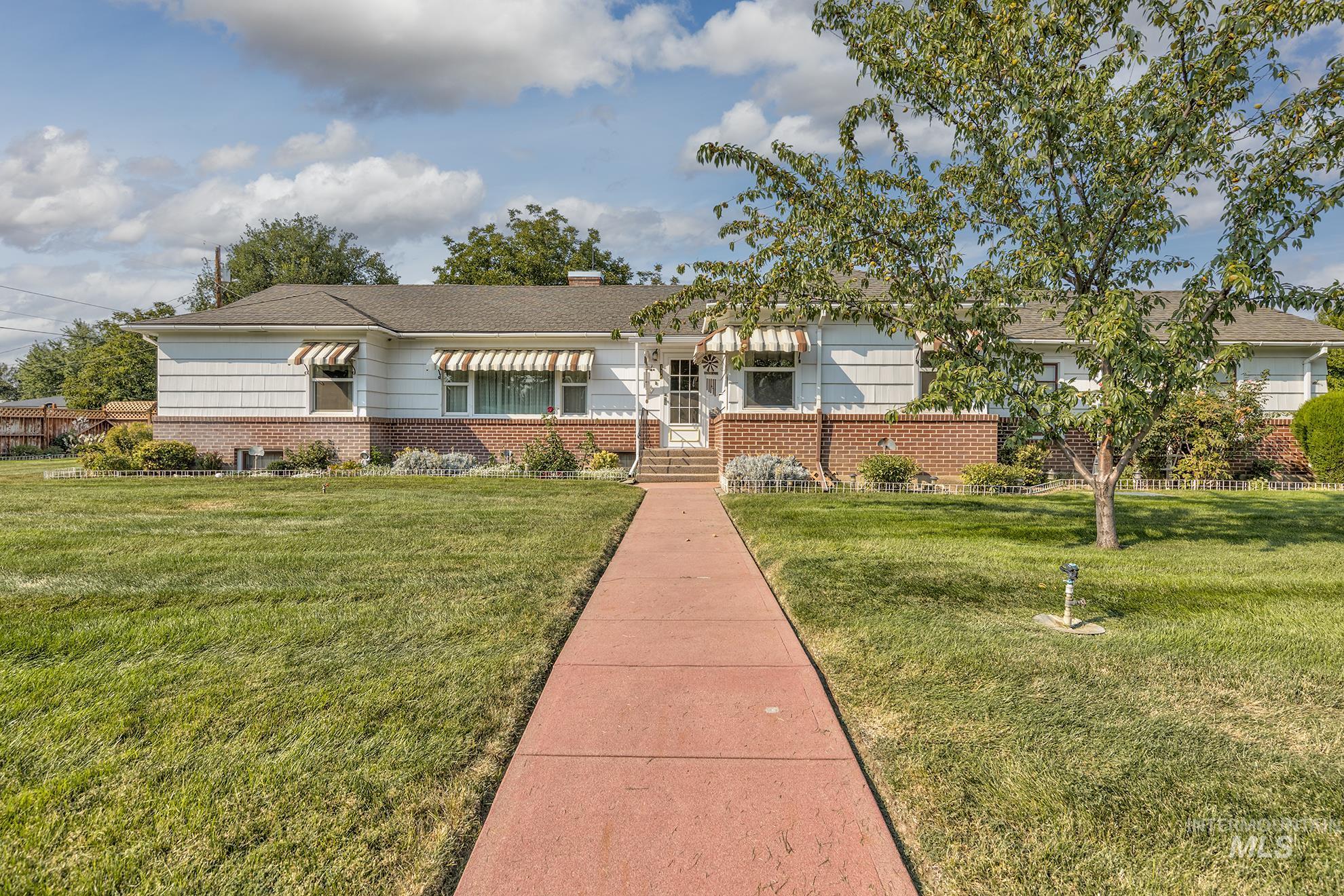 Single story home with a front yard, brick siding, and a chimney