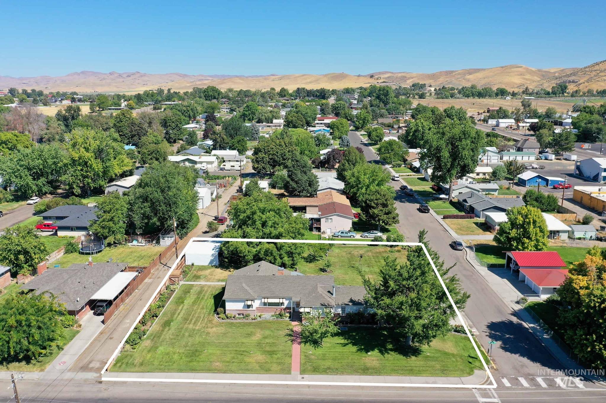 Aerial view of residential area featuring property parcel outlined and a mountain backdrop