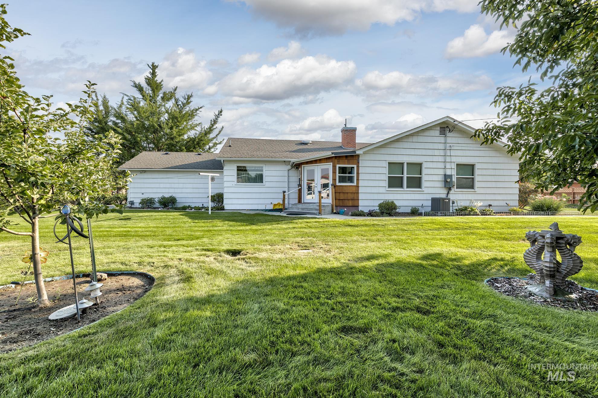 Rear view of property featuring a yard, a chimney, and entry steps