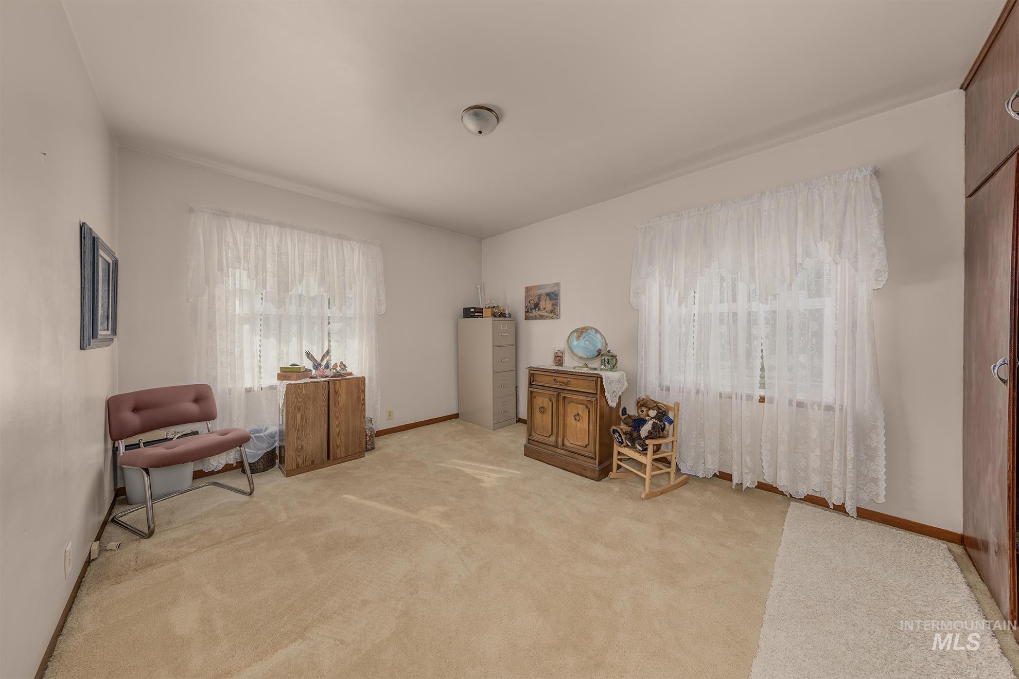 Sitting room with plenty of natural light and light colored carpet