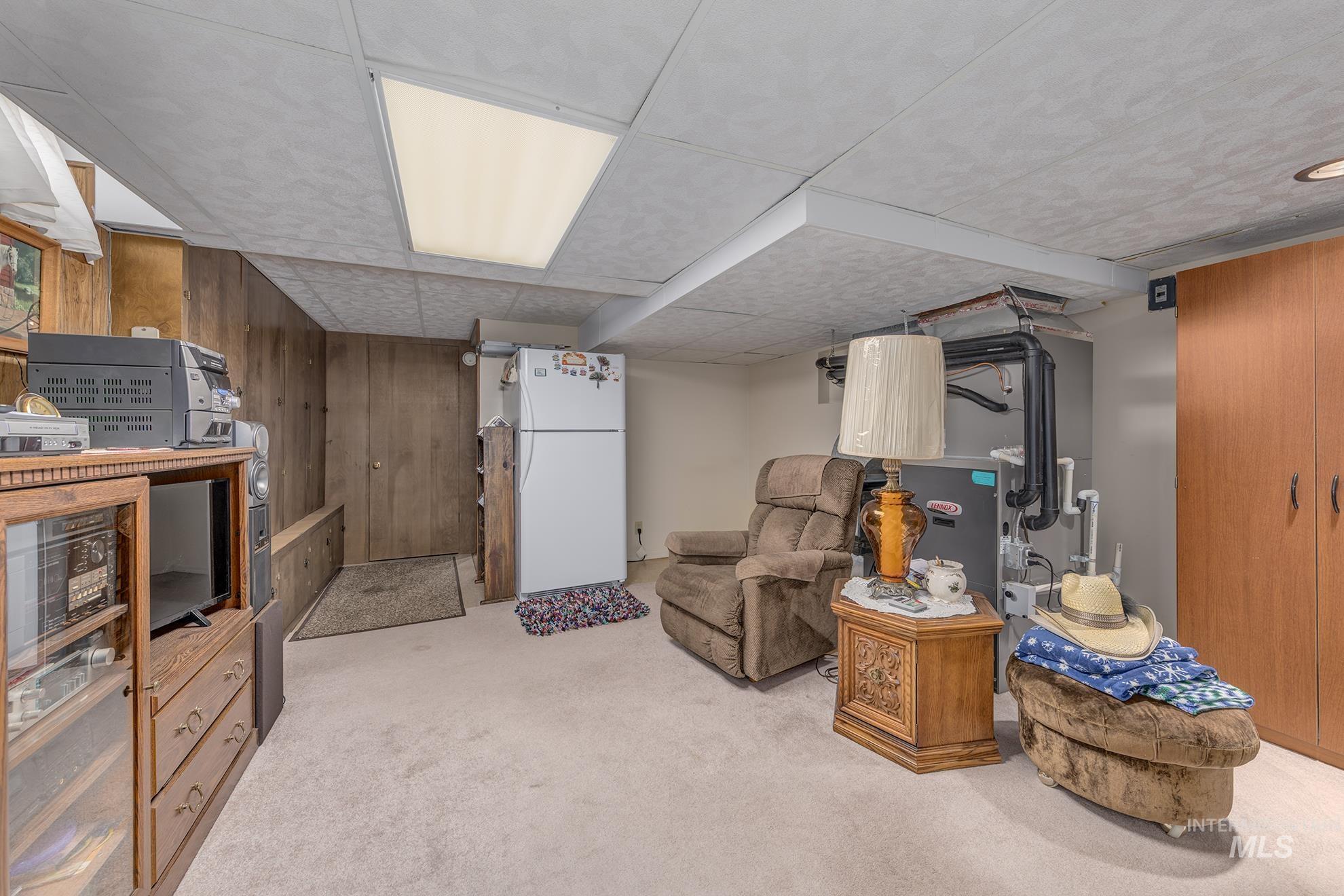 Living area with wood walls and light carpet