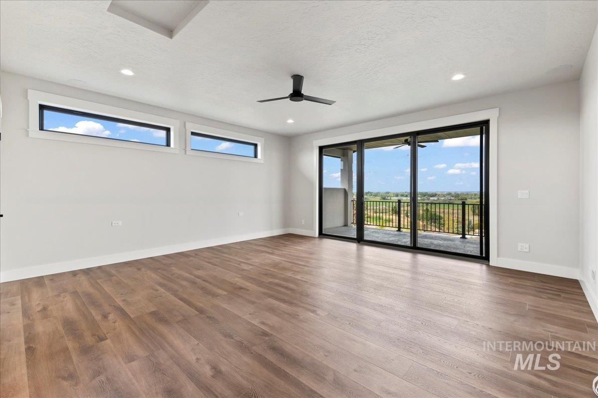 Empty room with ceiling fan, a textured ceiling, light wood-style flooring, and recessed lighting