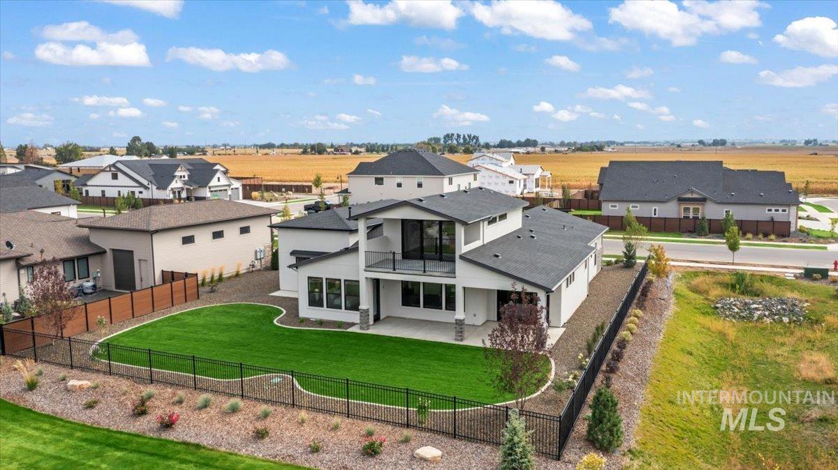 Back of house with a balcony, a fenced backyard, a patio, and stucco siding