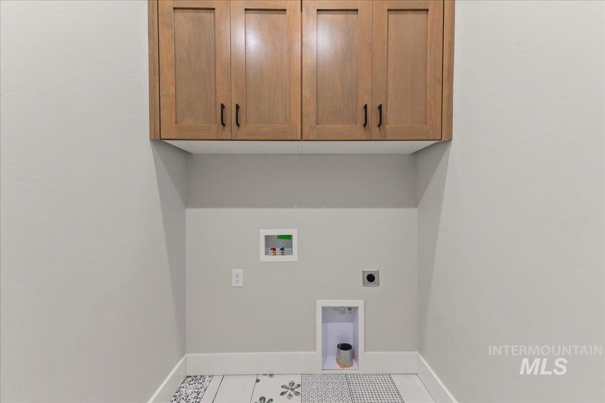 Laundry room with washer hookup, hookup for an electric dryer, cabinet space, and tile patterned flooring