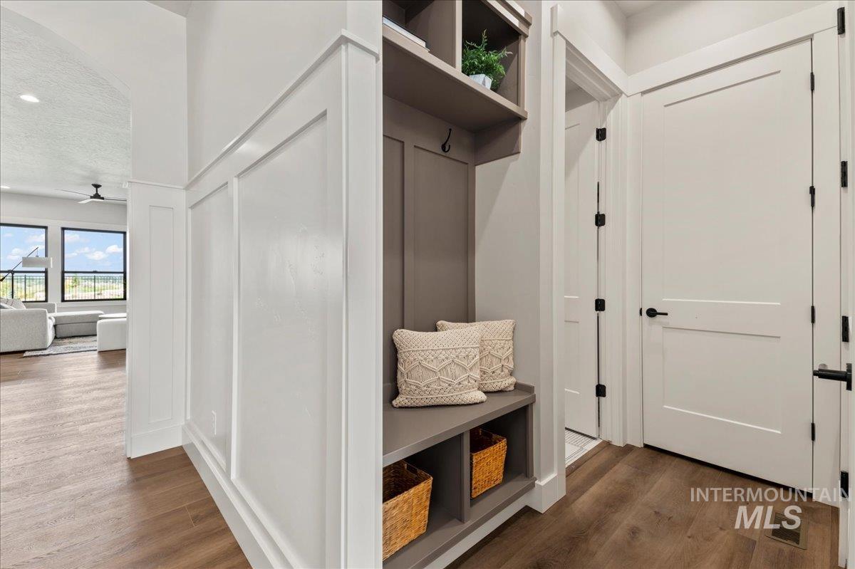 Mudroom featuring dark wood-style flooring, a ceiling fan, and a textured ceiling