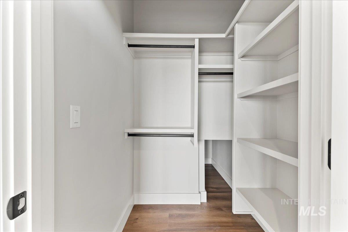 Spacious closet featuring dark wood-style floors
