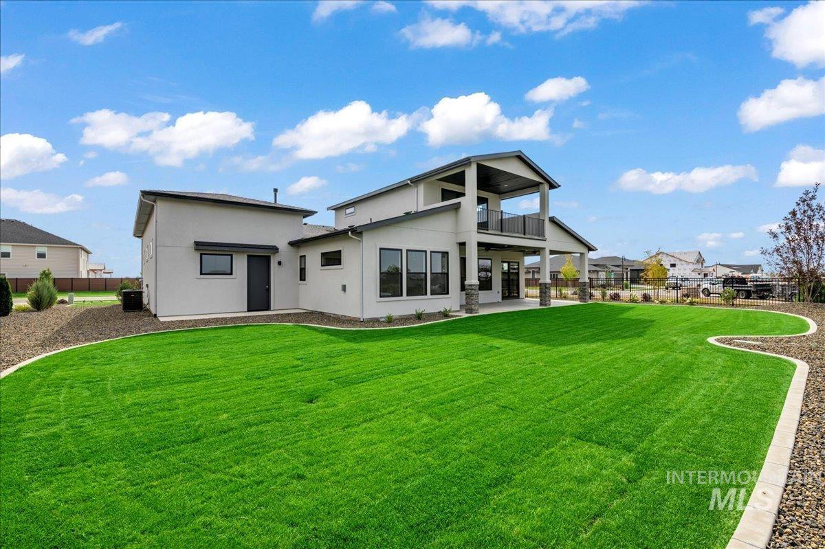 Back of property featuring a balcony, a patio area, and stucco siding