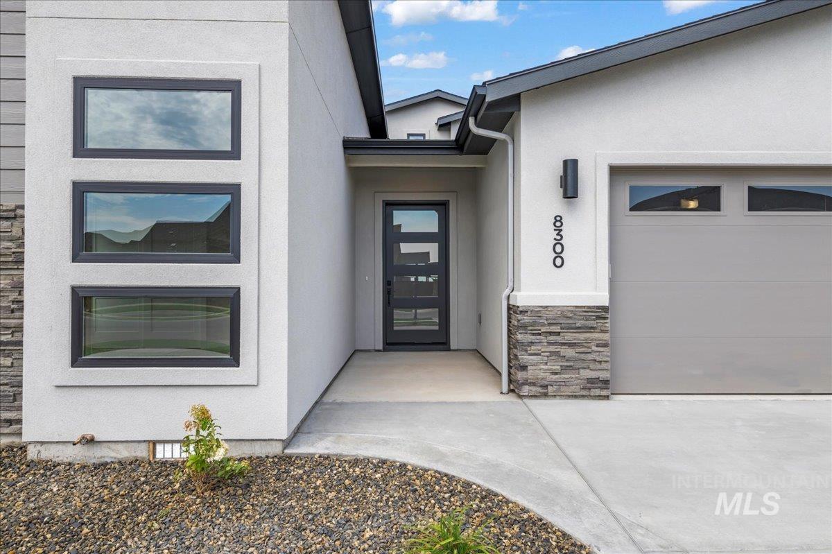 Doorway to property with stone siding and stucco siding