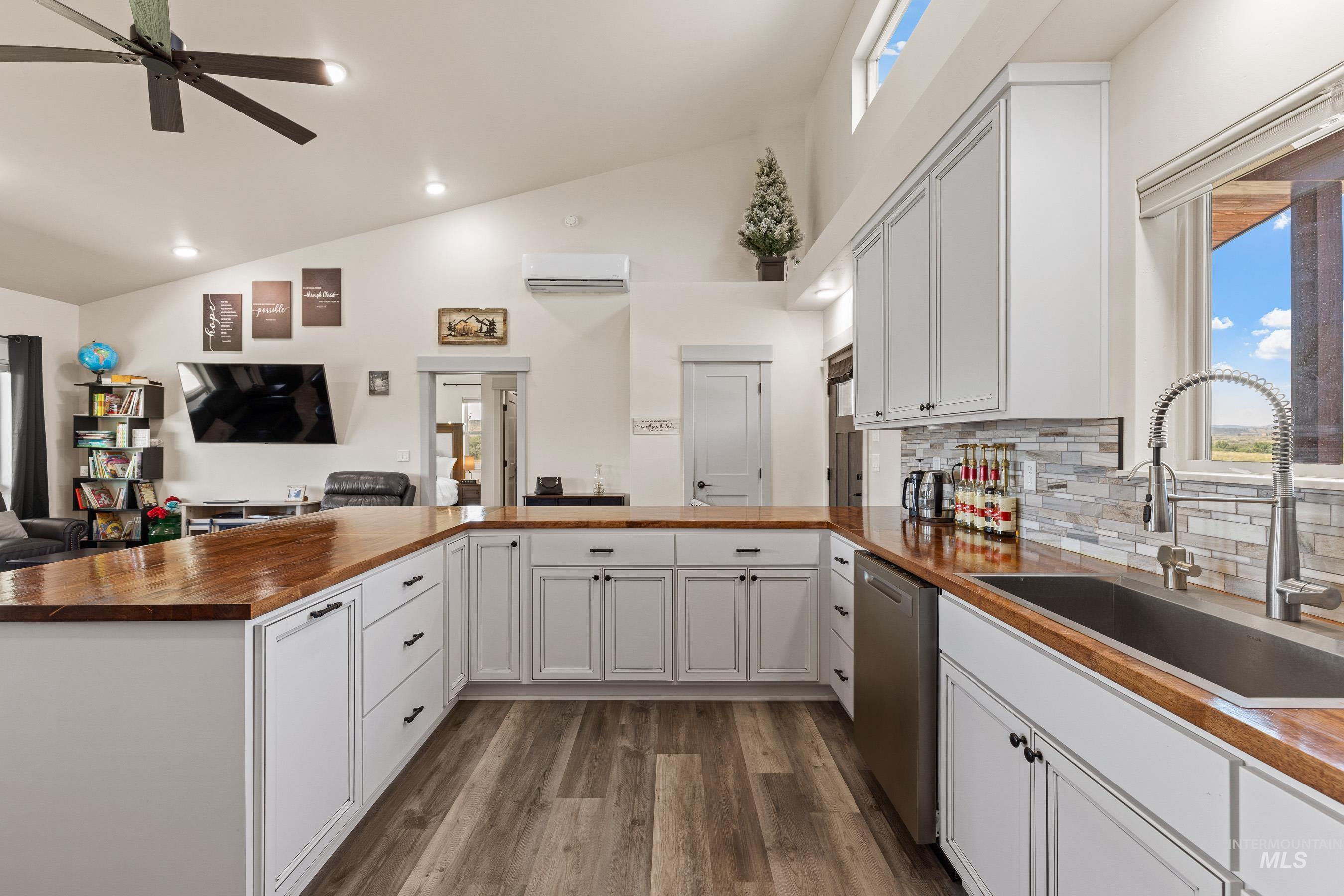 Kitchen featuring wood counters, open floor plan, stainless steel dishwasher, healthy amount of natural light, and recessed lighting