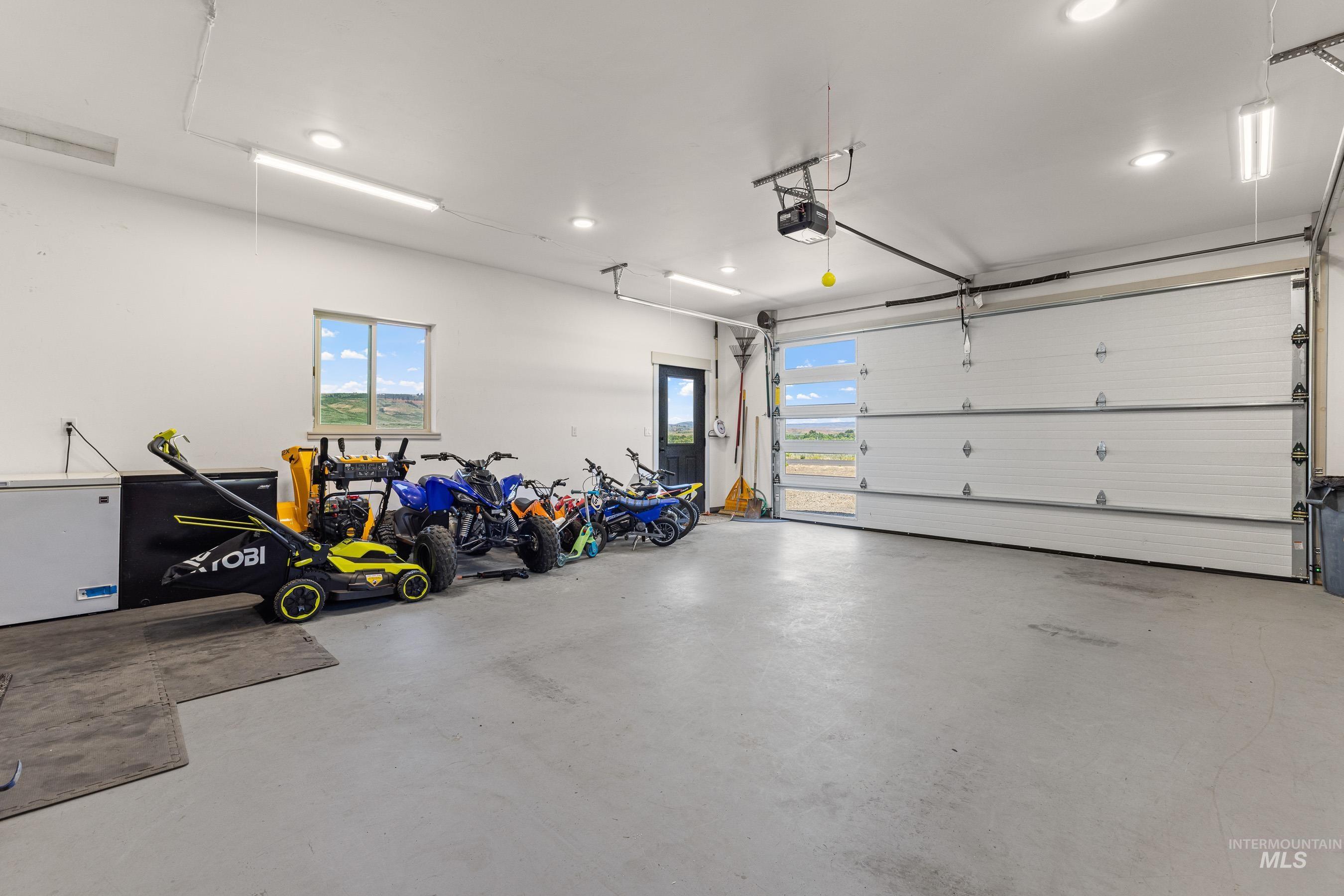 Garage featuring a garage door opener, recessed lighting, and fridge