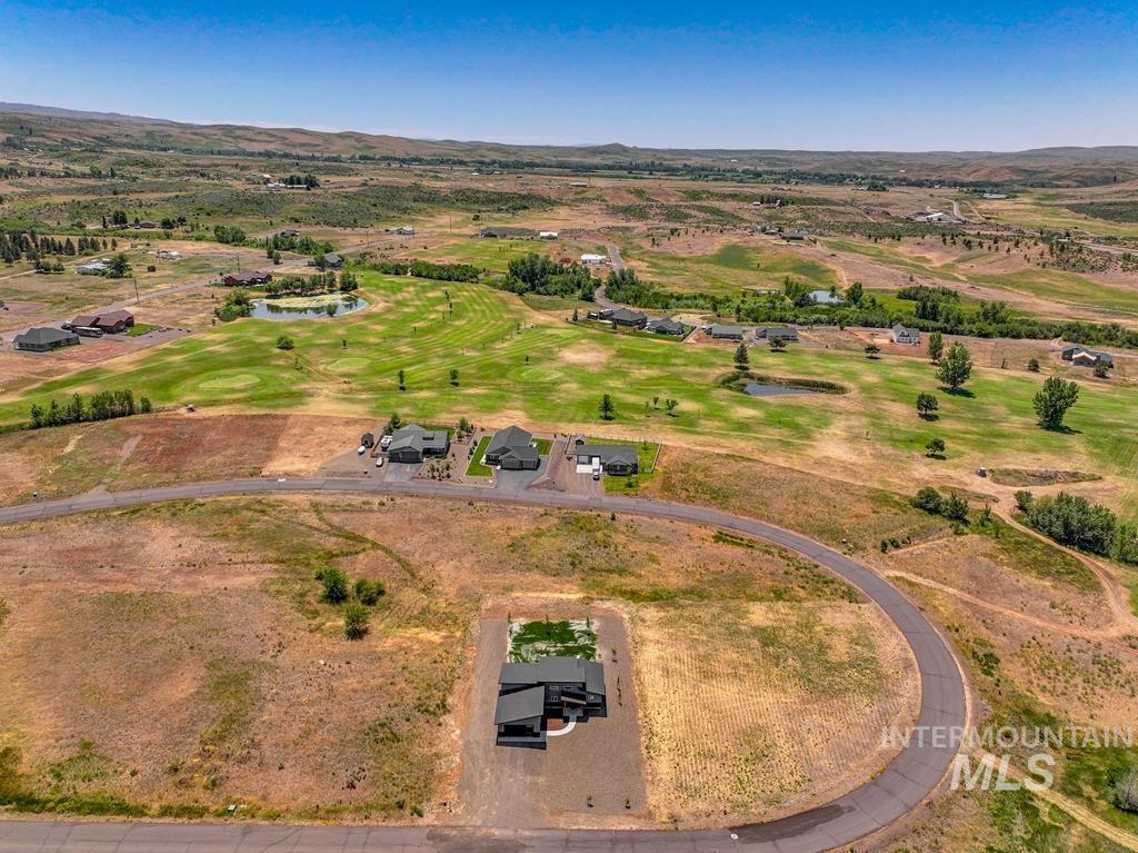 Aerial view of property and surrounding area with a water and mountain view and a local golf course