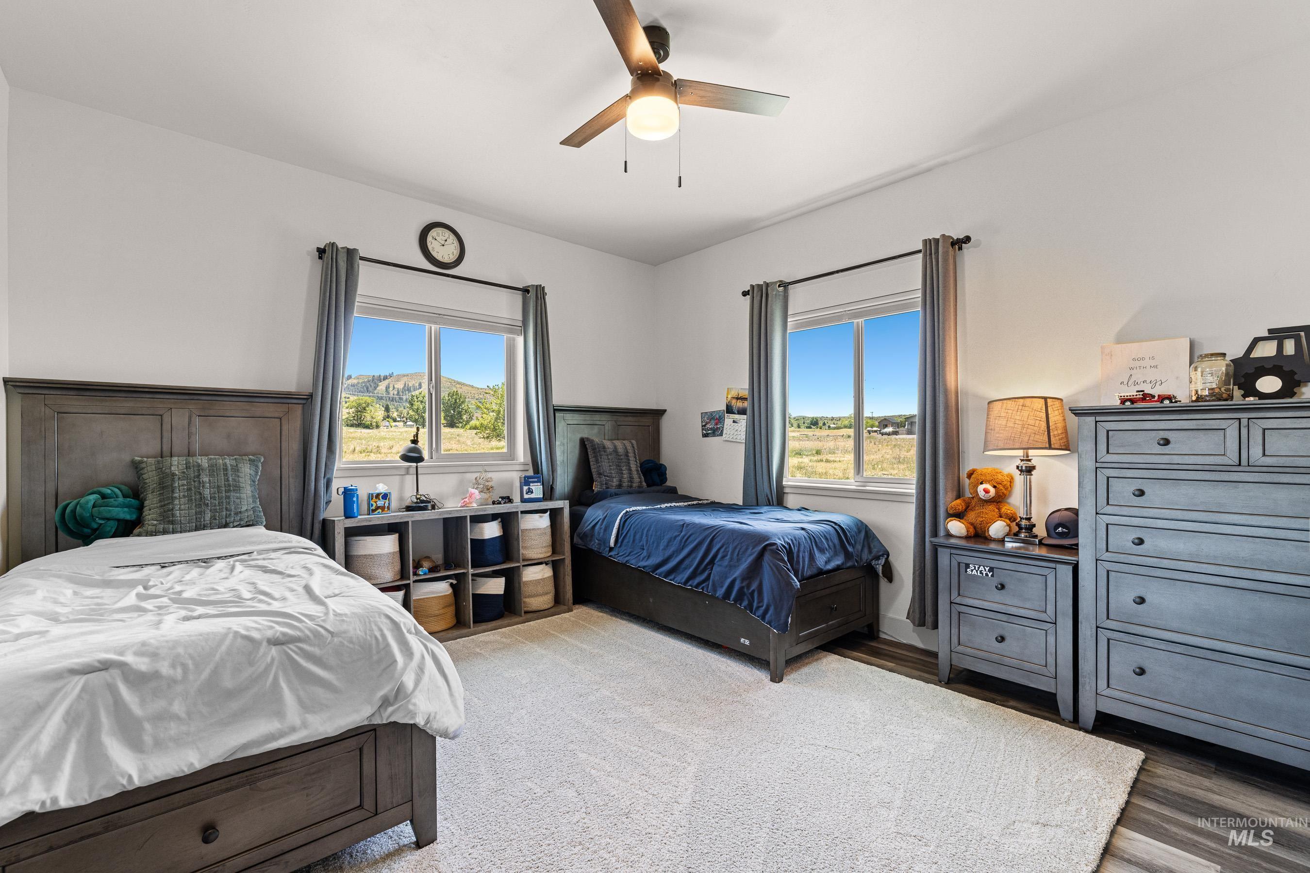 Bedroom featuring multiple windows, a ceiling fan, and wood finished floors