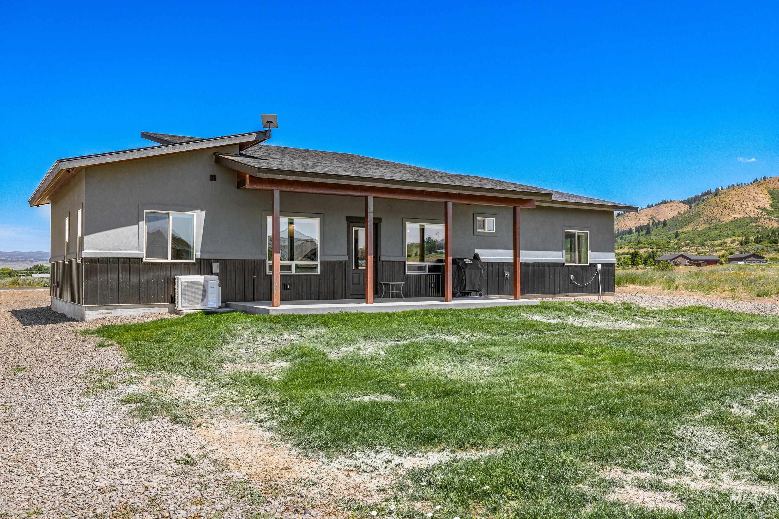 Back of house featuring a yard, a patio, stucco siding, and a mountain view