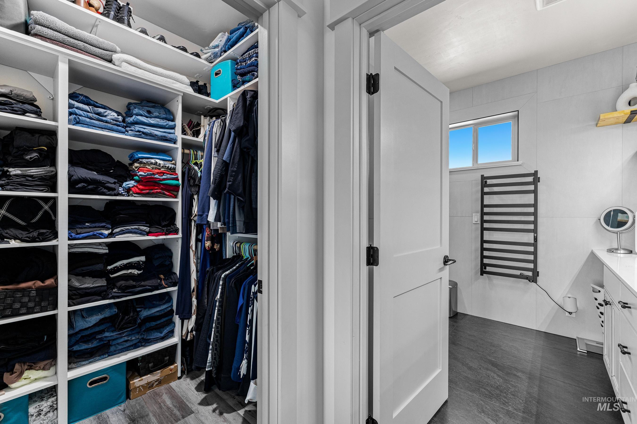 Spacious closet with radiator heating unit and wood finished floors