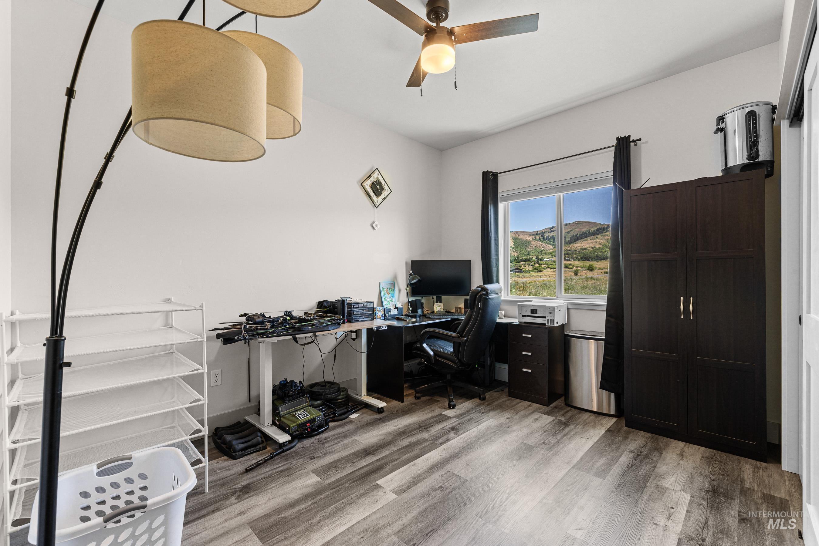 Home office featuring light wood-style floors and a ceiling fan