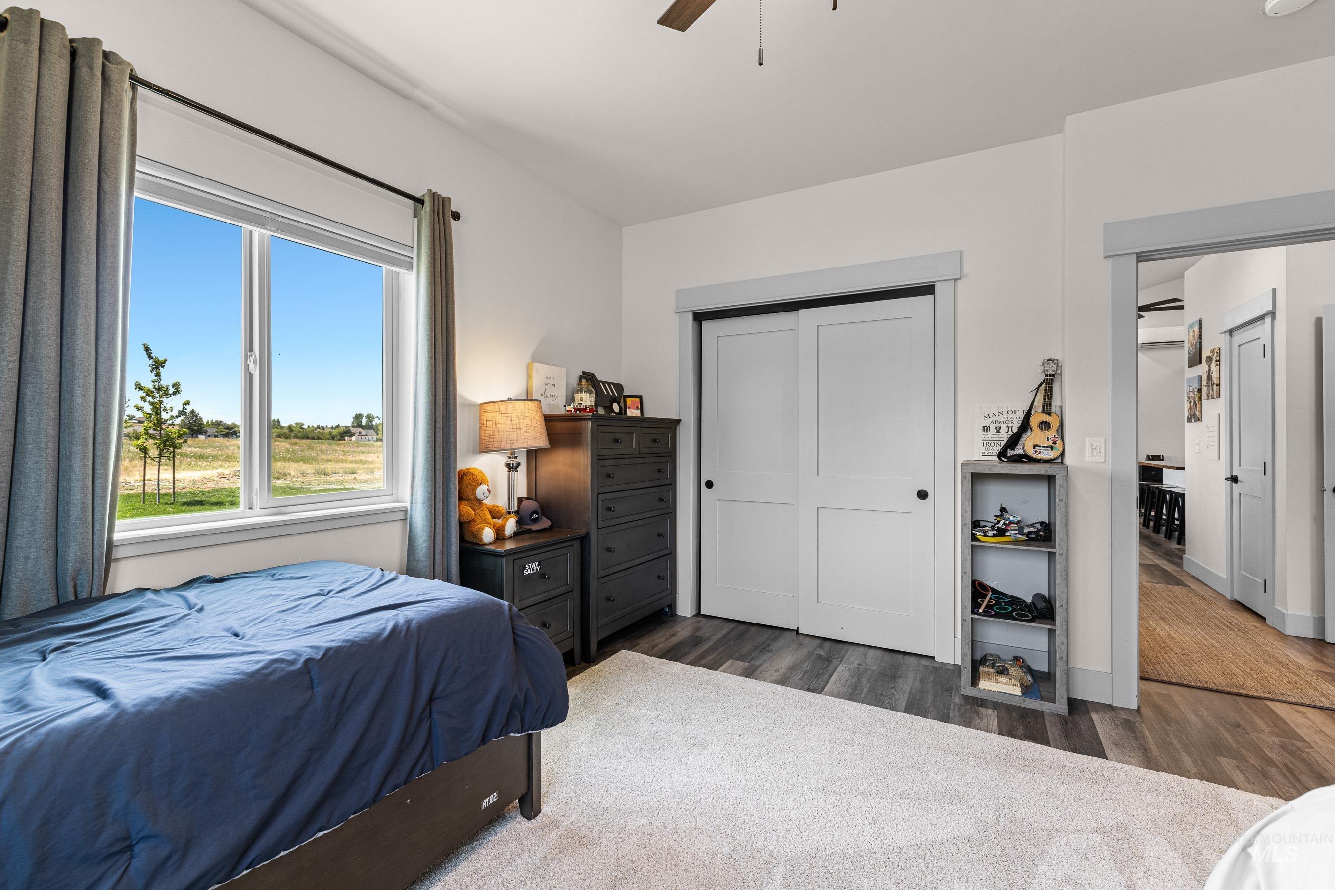 Bedroom featuring wood finished floors, a ceiling fan, and a closet