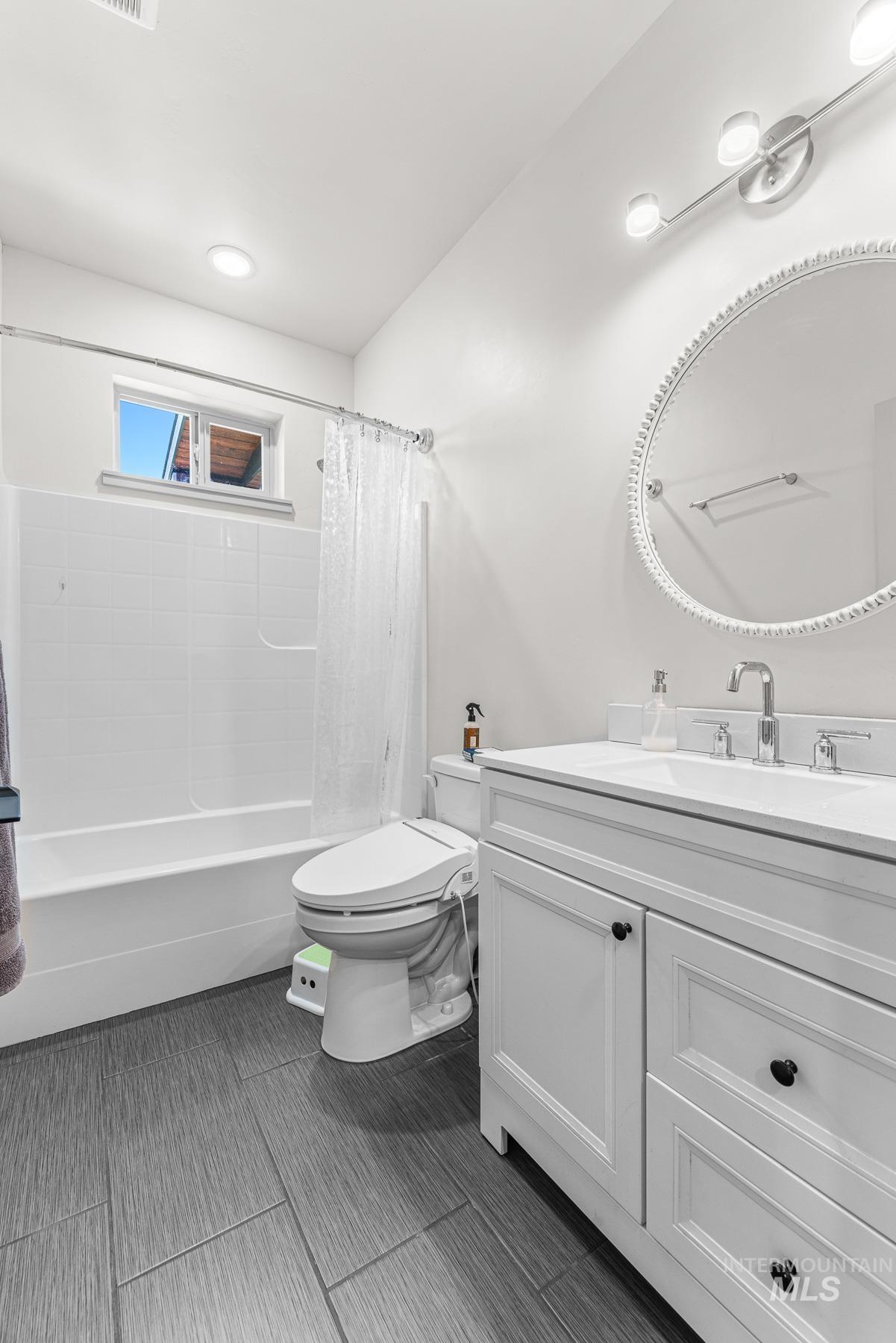 Bathroom featuring vanity and shower / tub combo with curtain
