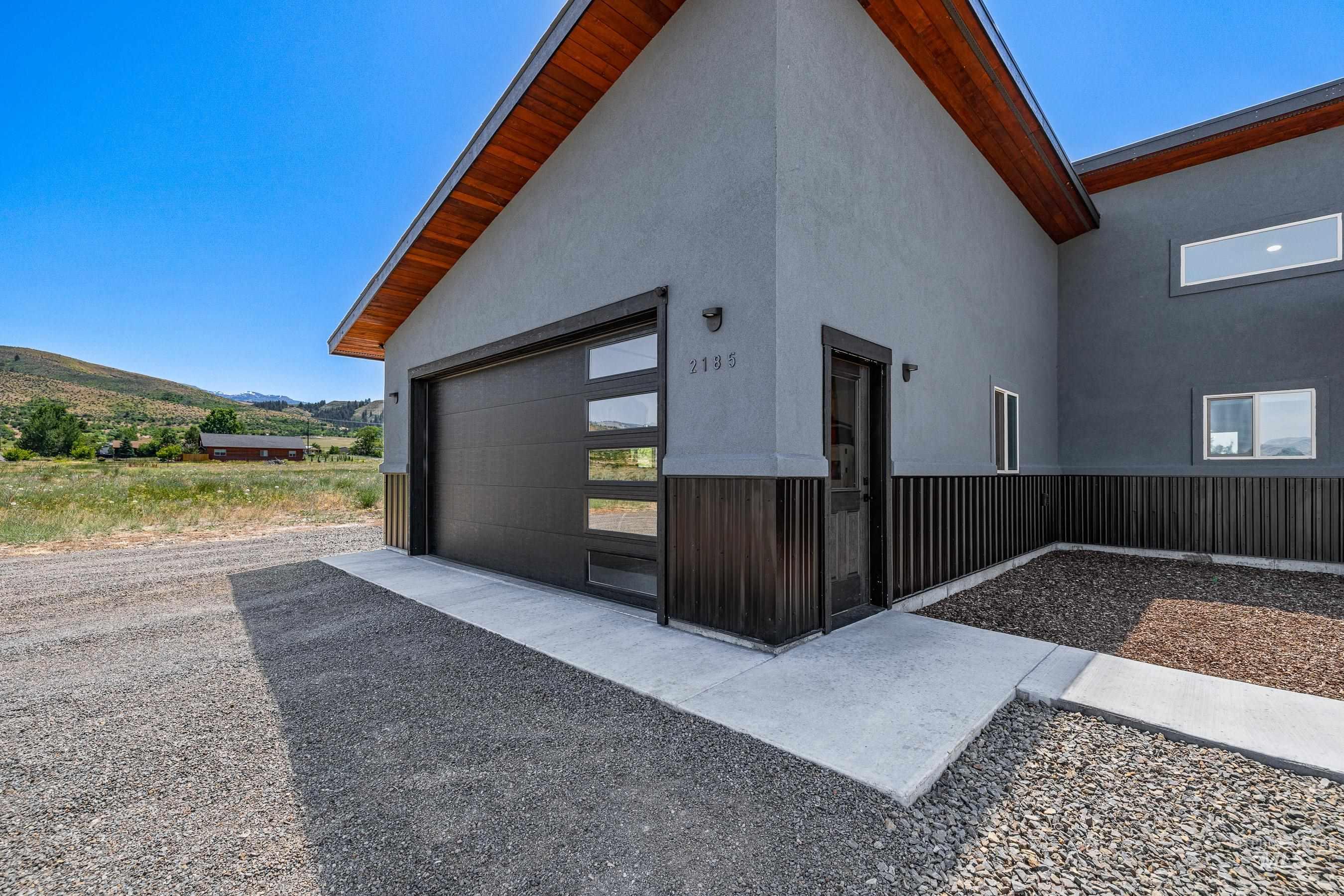 View of property's community featuring a garage, a mountain view, and driveway
