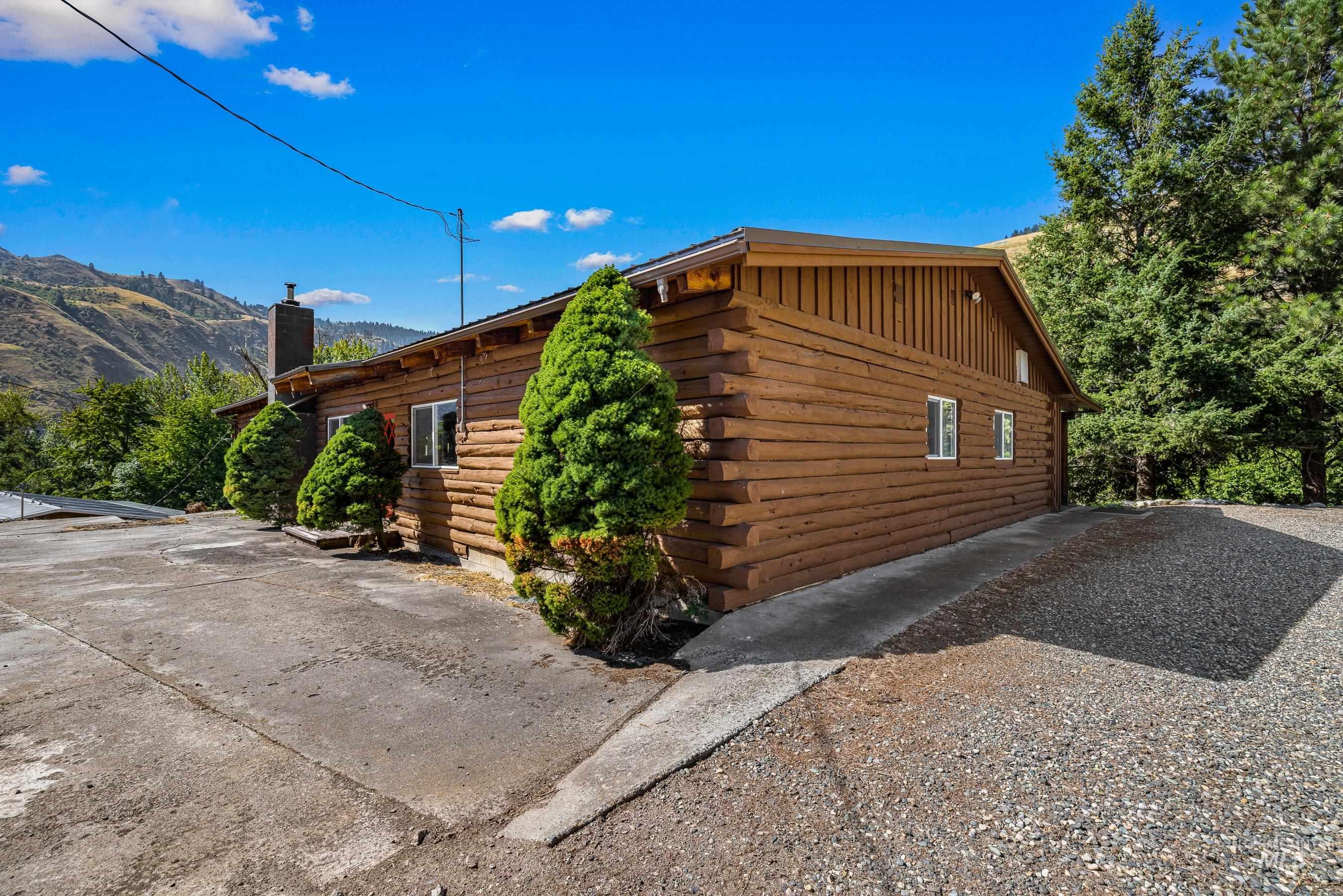 View of home's exterior featuring log exterior, board and batten siding, and a chimney